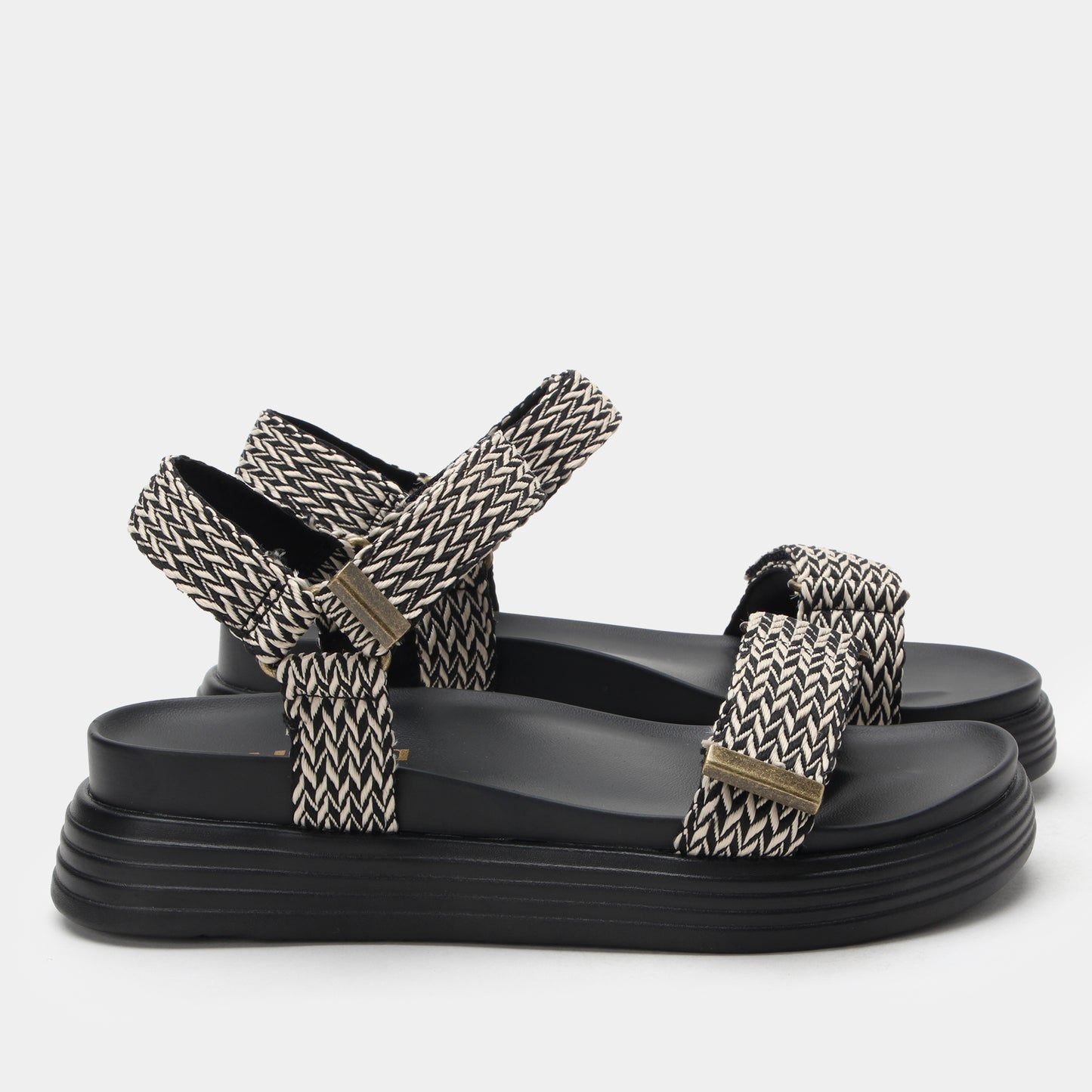 Black sandals with patterned straps on a white background