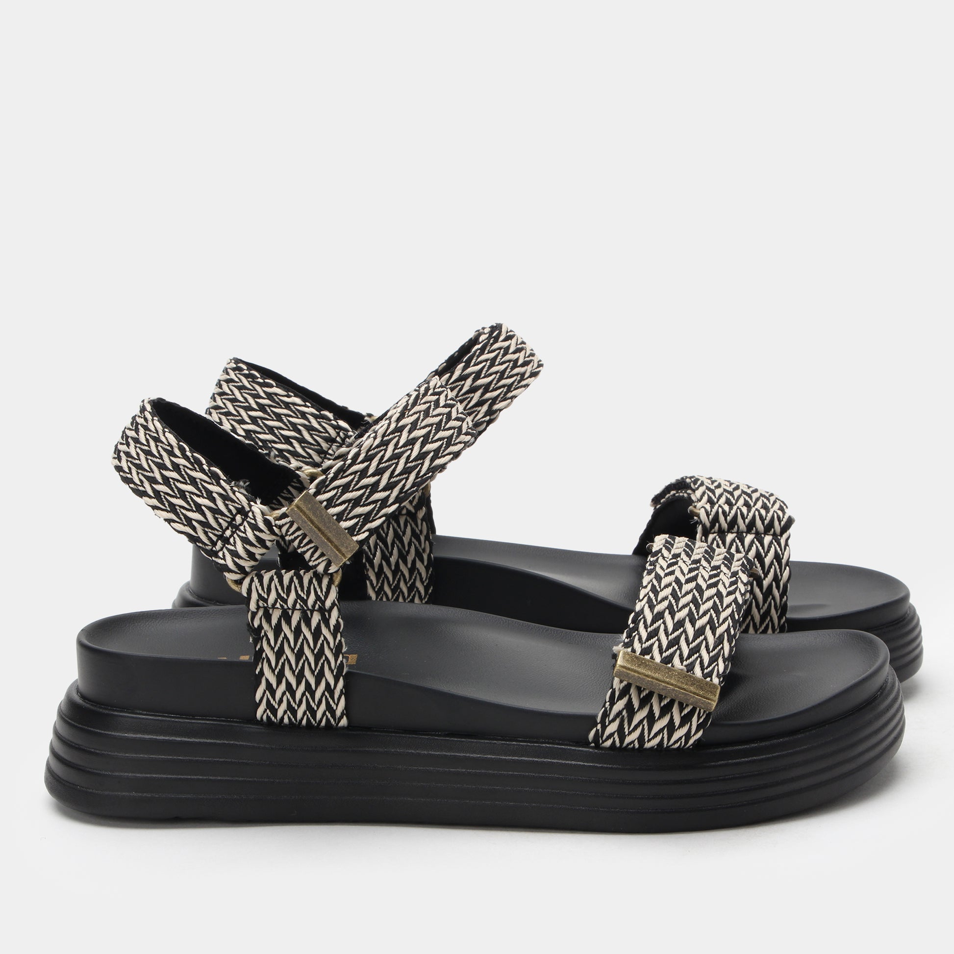 Black sandals with patterned straps on a white background