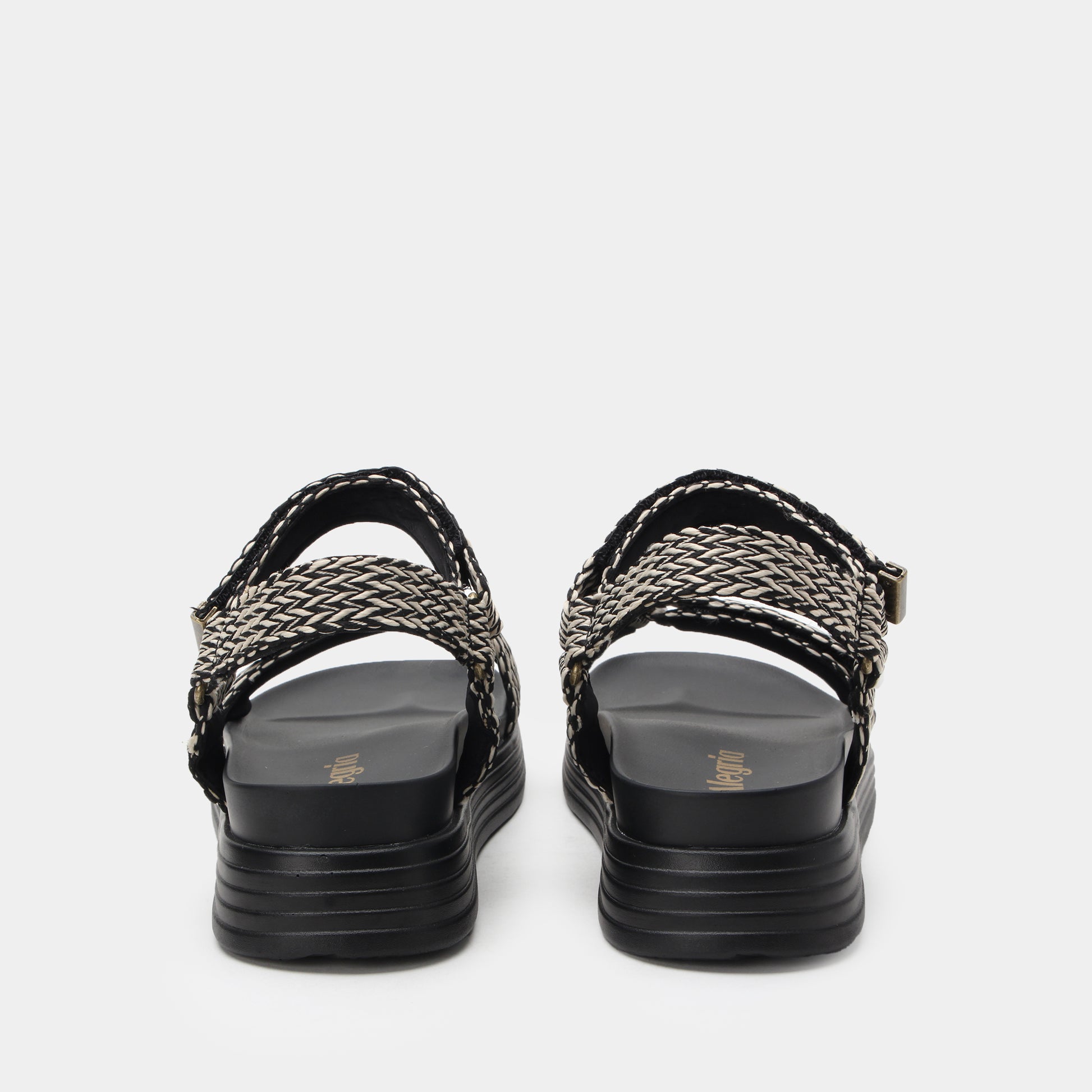 Black sandals with woven straps on a white background