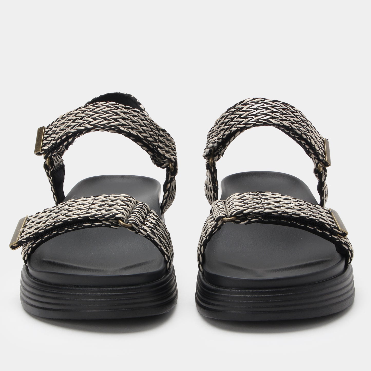 Black sandals with woven straps on a white background