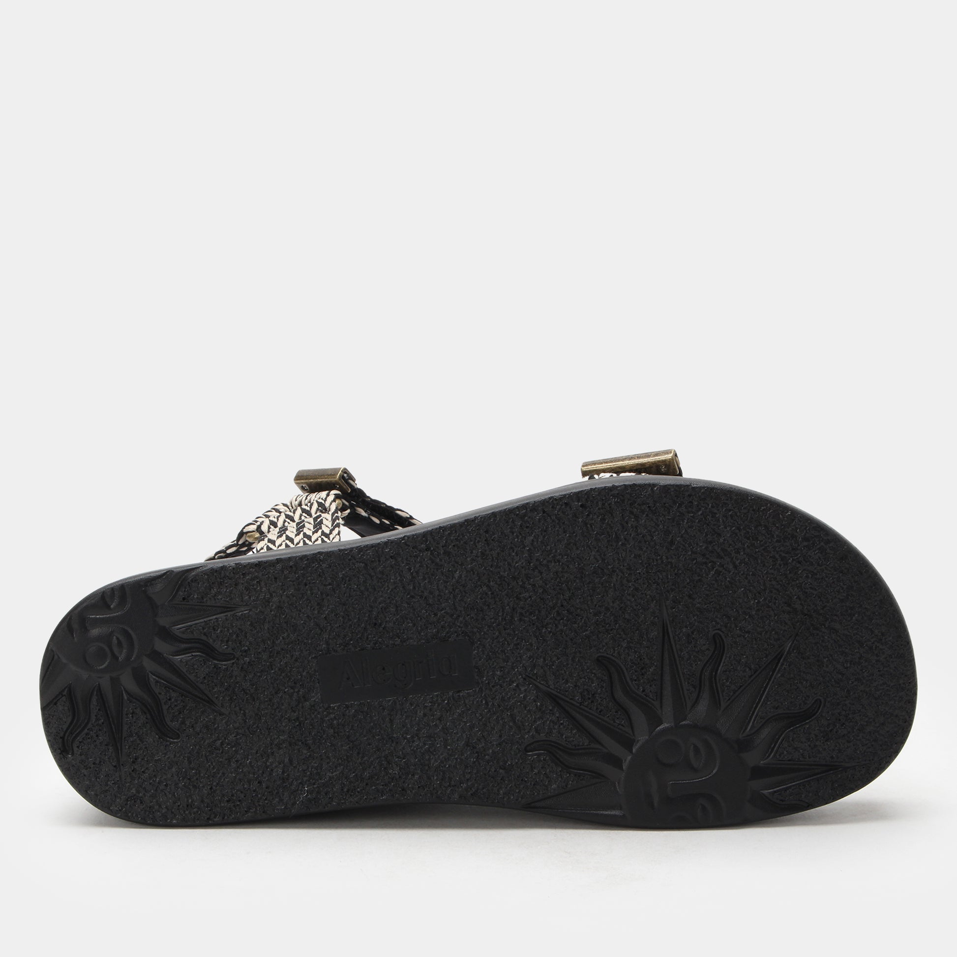 Black sandal sole with brand logo on a light gray background