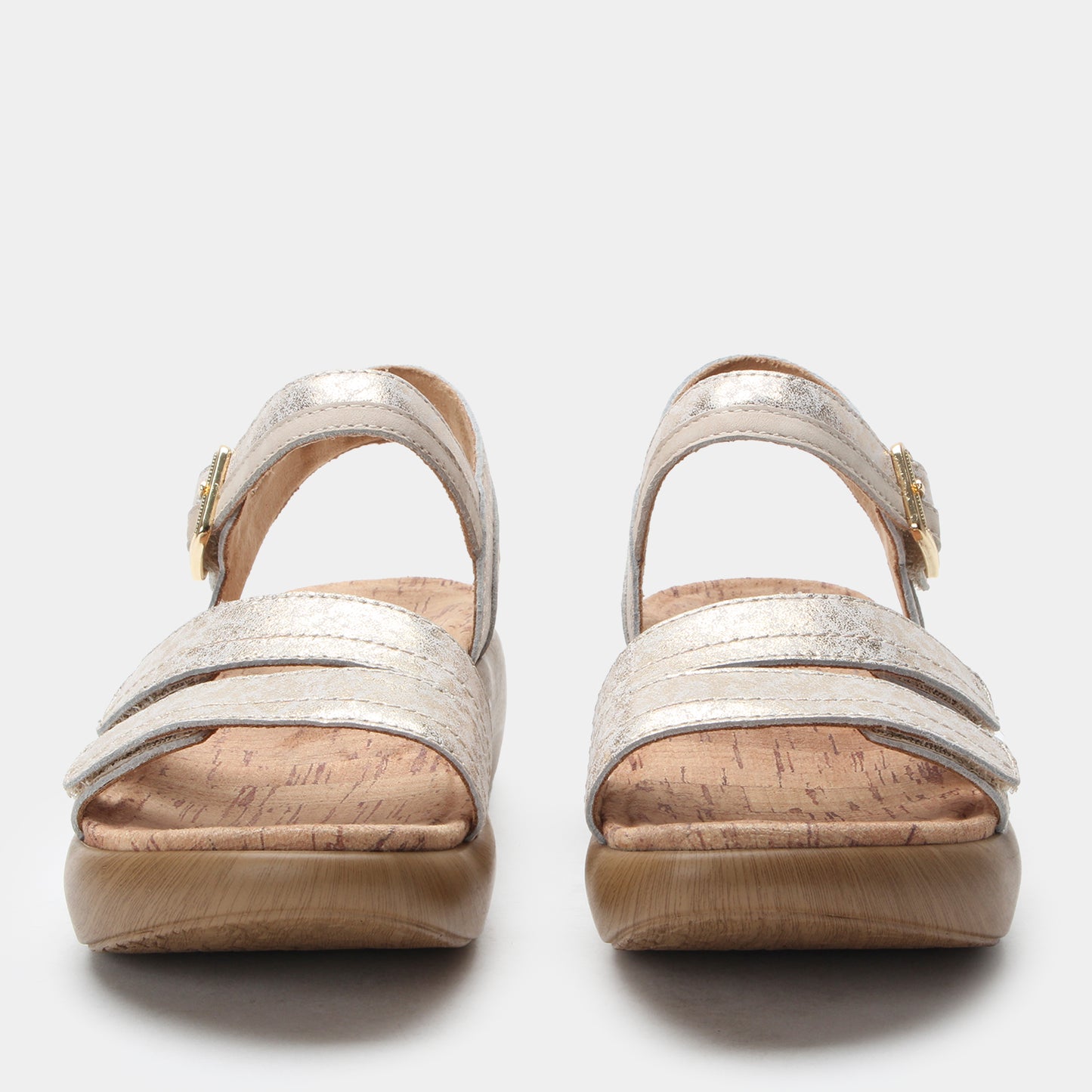 Pair of silver sandals with cork soles on a white background