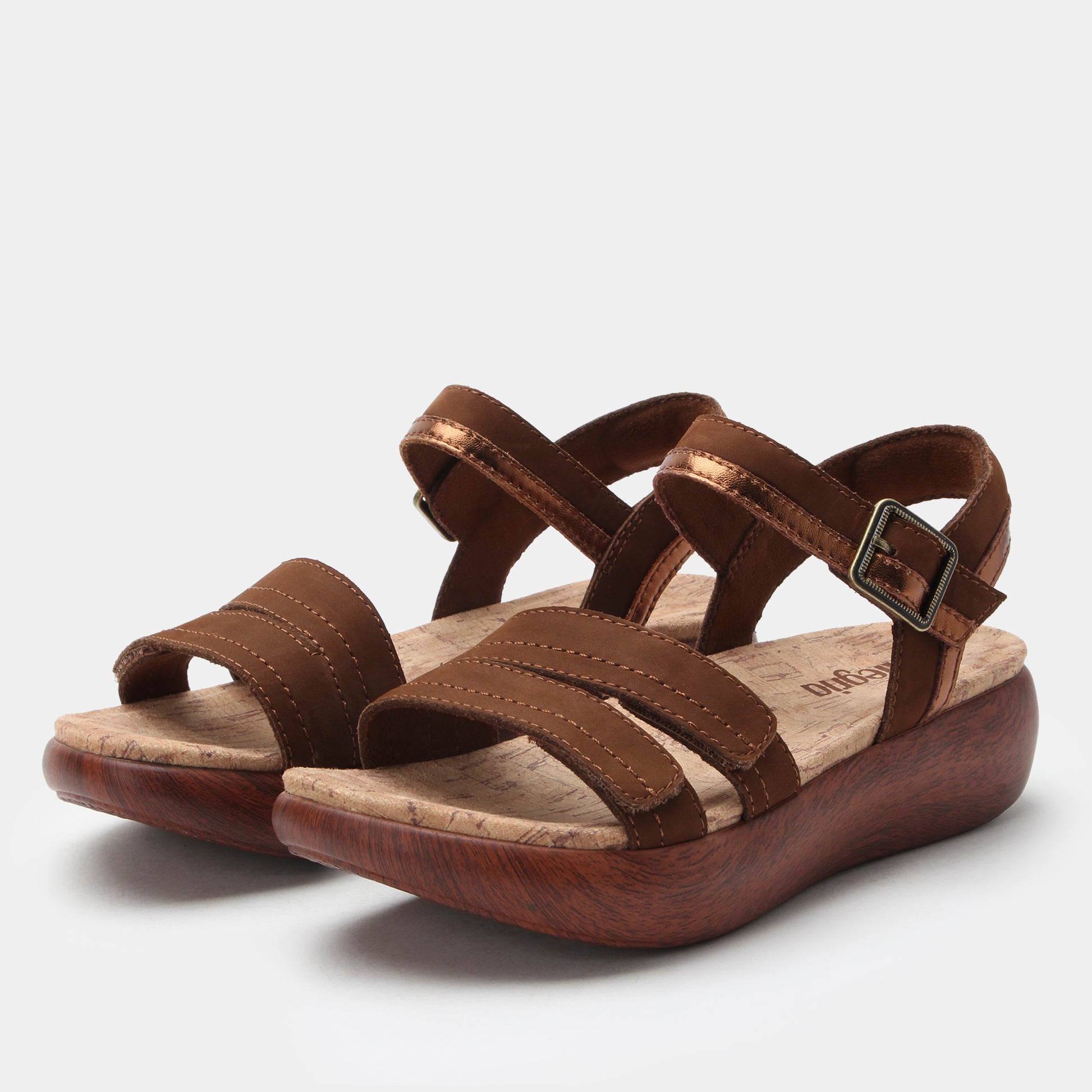 Brown sandals with multiple straps on a light gray background