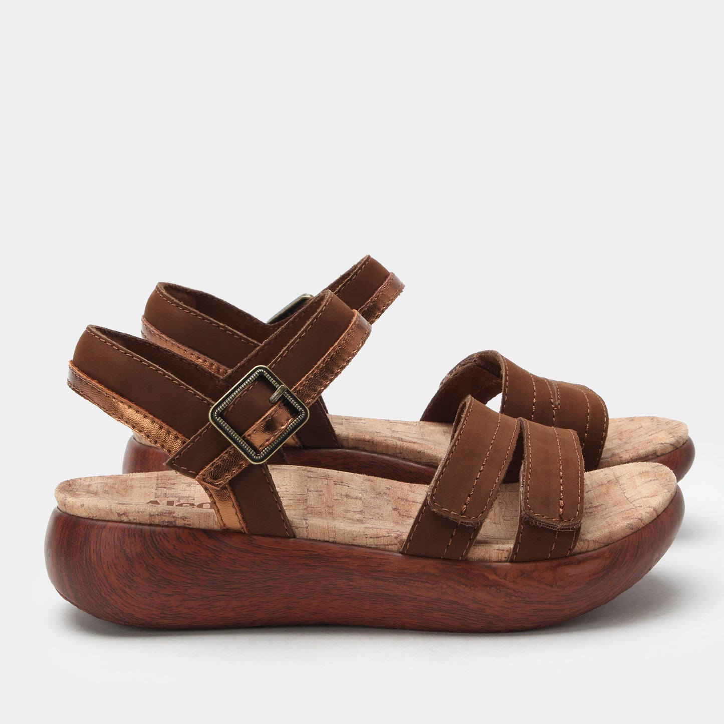 Brown platform sandals with multiple straps on a light gray background