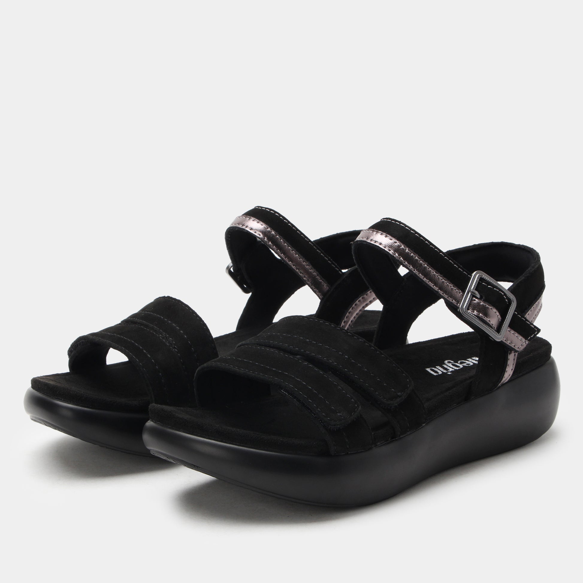 Black sandals with multiple straps on a light gray background