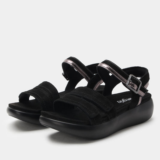 Black sandals with multiple straps on a light gray background
