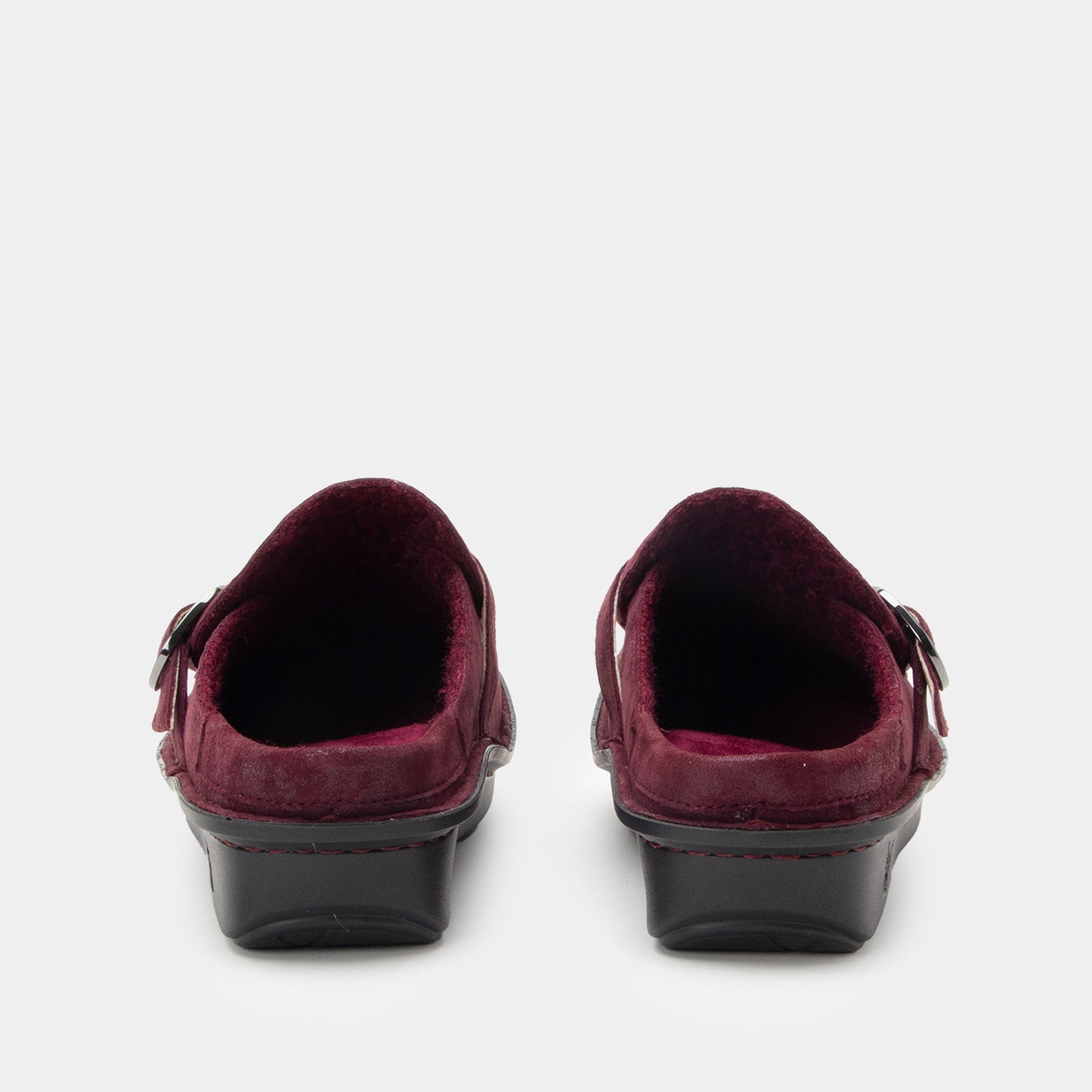 Pair of maroon shoes with buckles on a white background