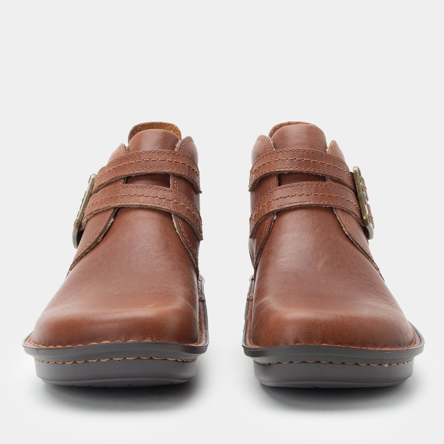 Pair of brown leather shoes with velcro straps on a white background