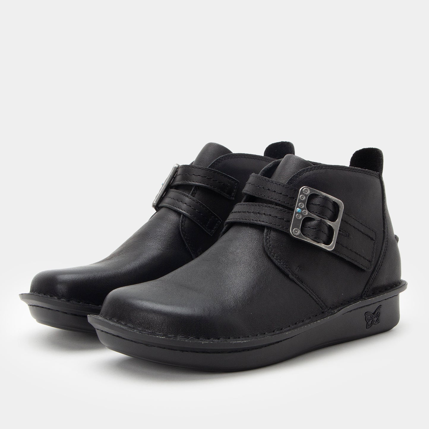 Pair of black leather boots with buckles on a white background