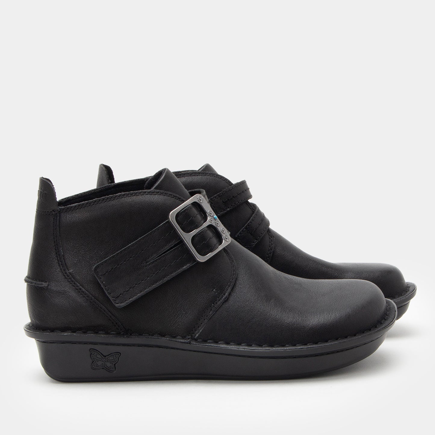 Black ankle boots with a buckle on a white background