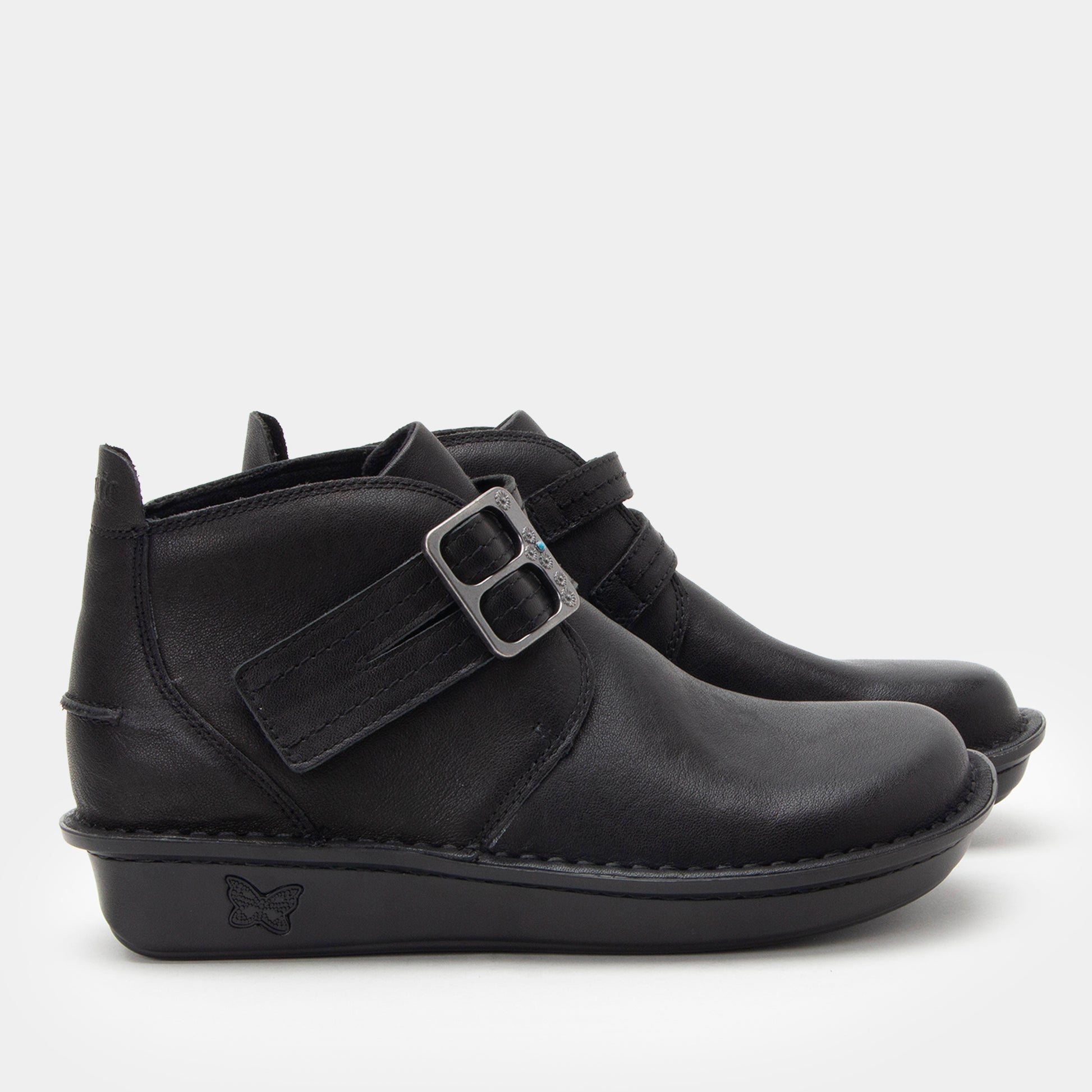 Black ankle boots with a buckle on a white background