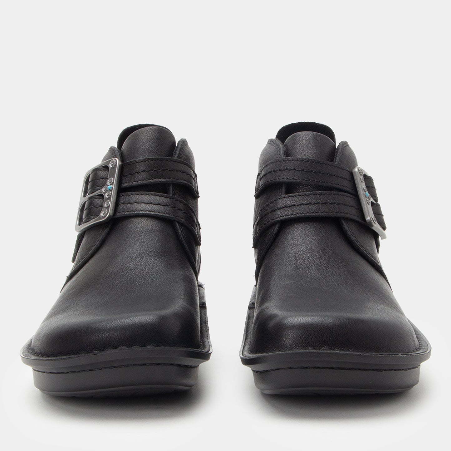 Pair of black leather shoes with velcro straps on a white background