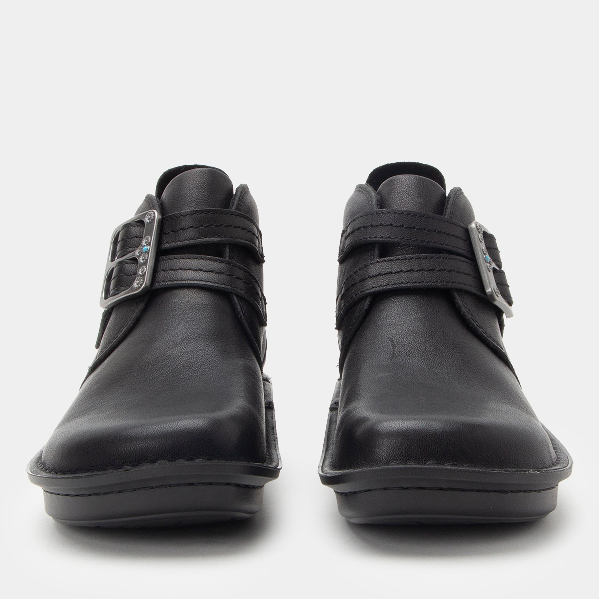 Pair of black leather shoes with velcro straps on a white background