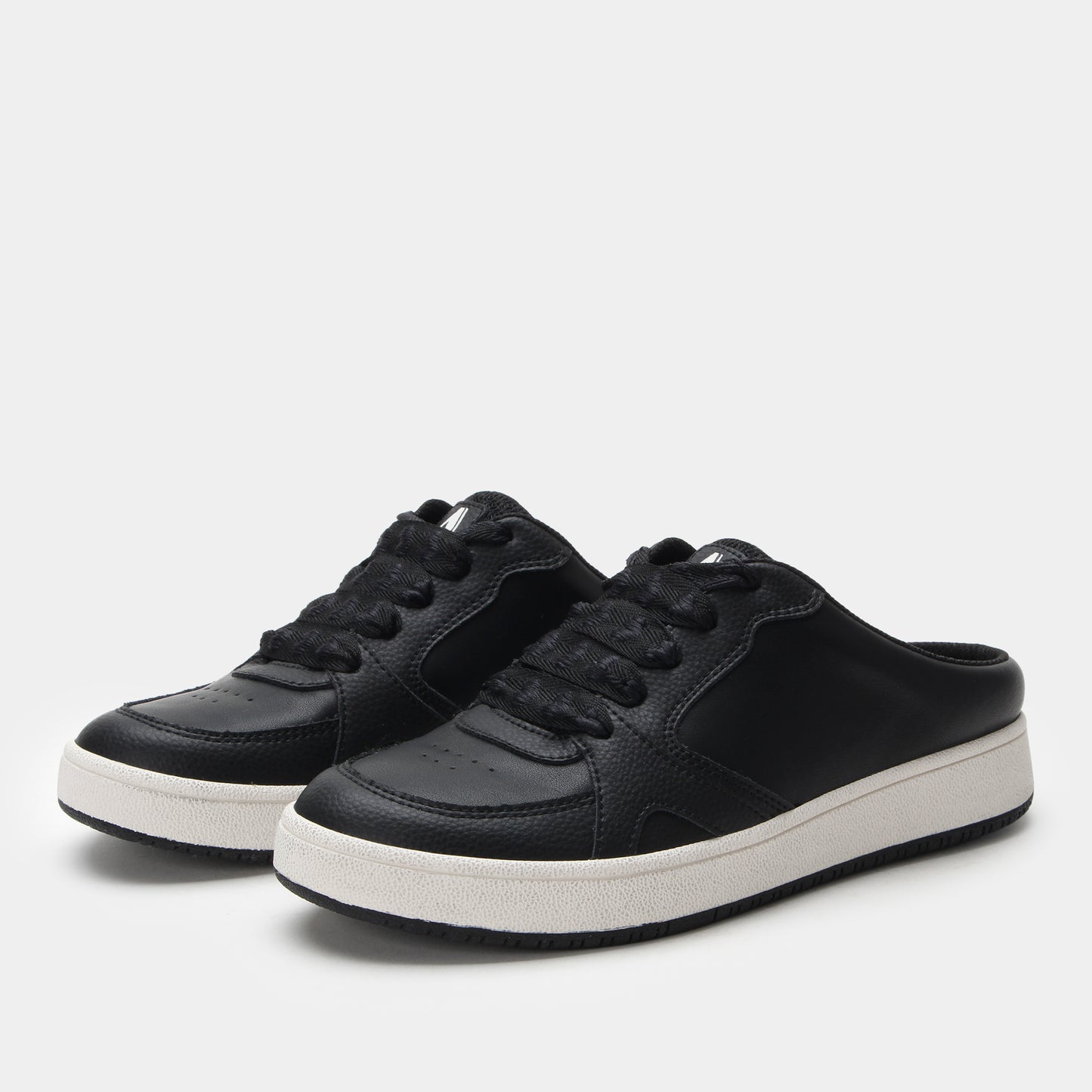 Black sneakers with white soles on a light gray background