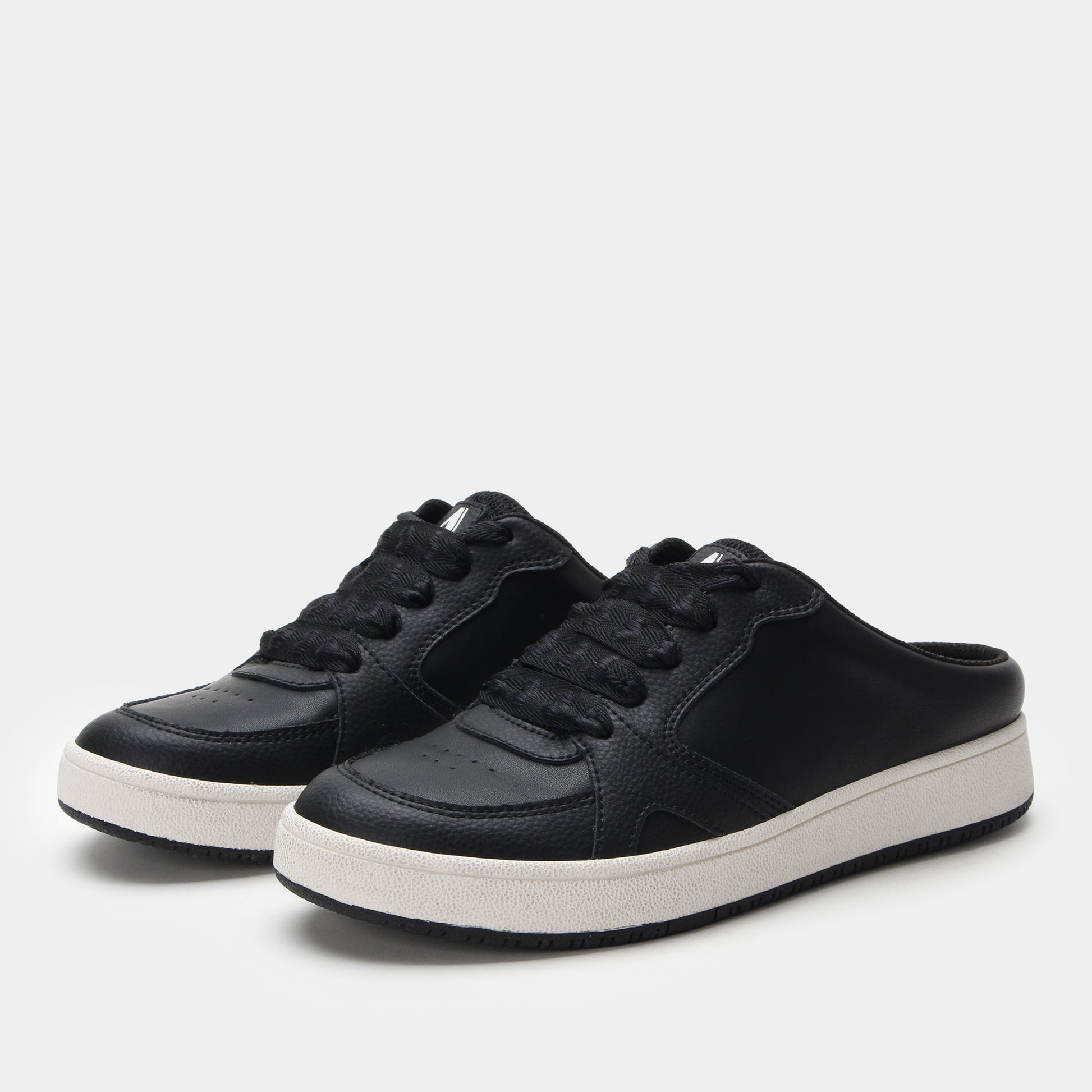 Black sneakers with white soles on a light gray background