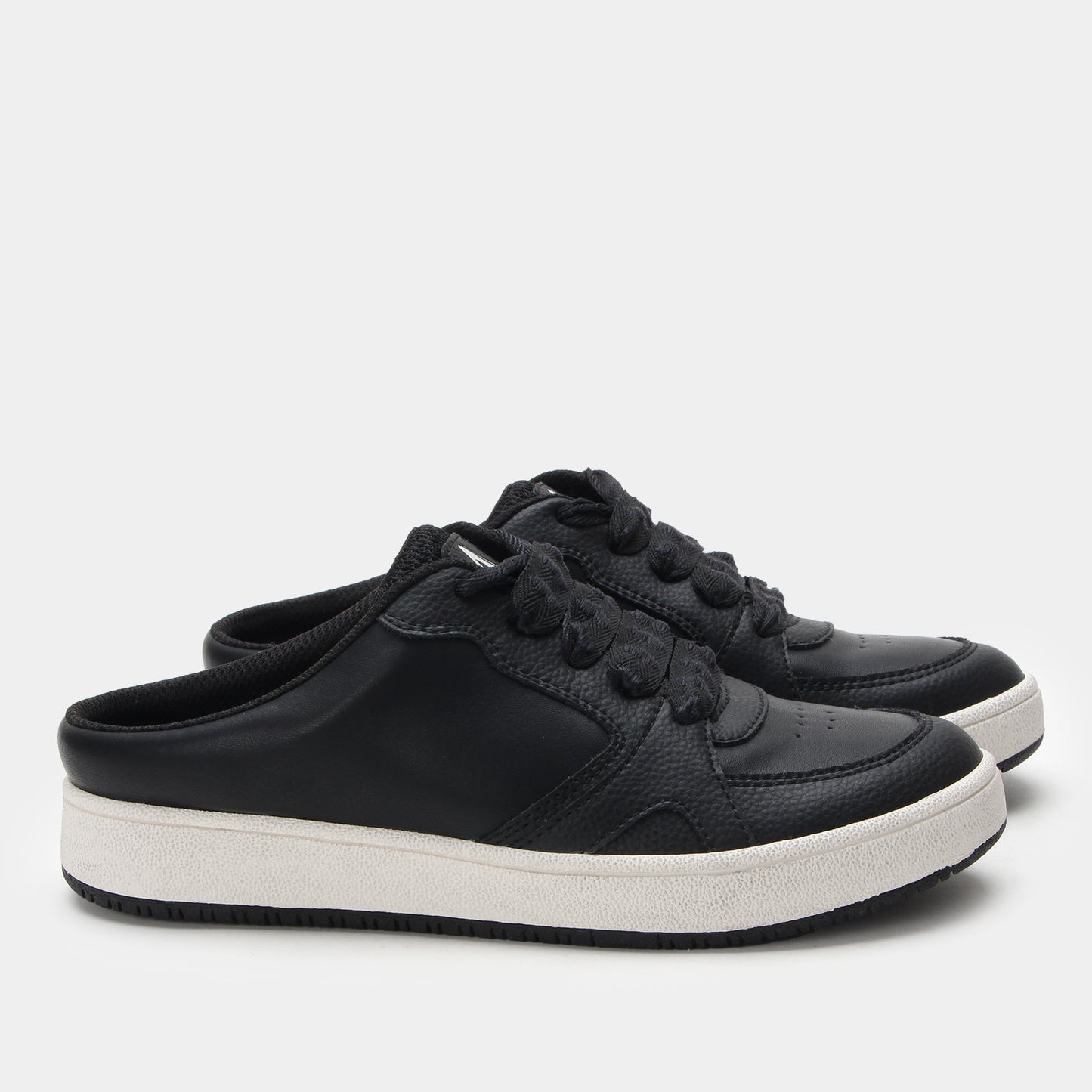Black sneakers with white soles on a light gray background