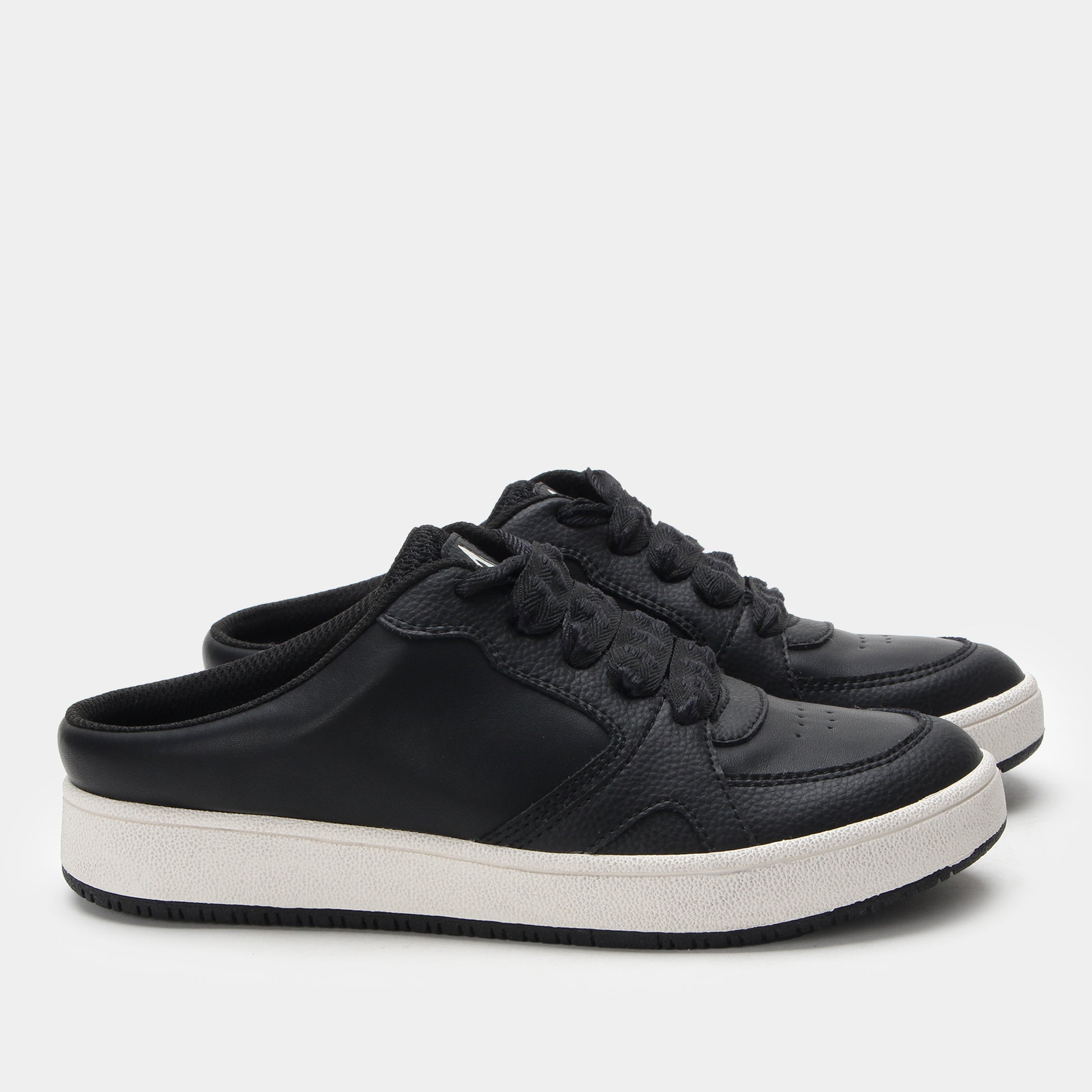 Black sneakers with white soles on a light gray background