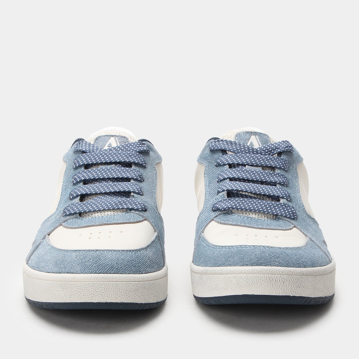 Pair of blue sneakers with white soles on a light gray background