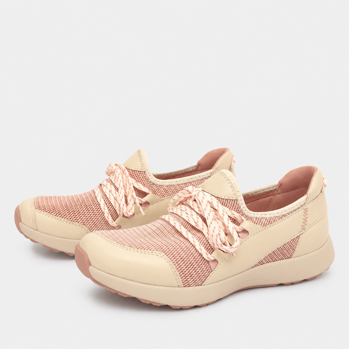A pair of casual slip-on sneakers in beige and dusty pink, featuring a knit upper, chunky laces, and a thick cushioned sole, shown against a light gray background.