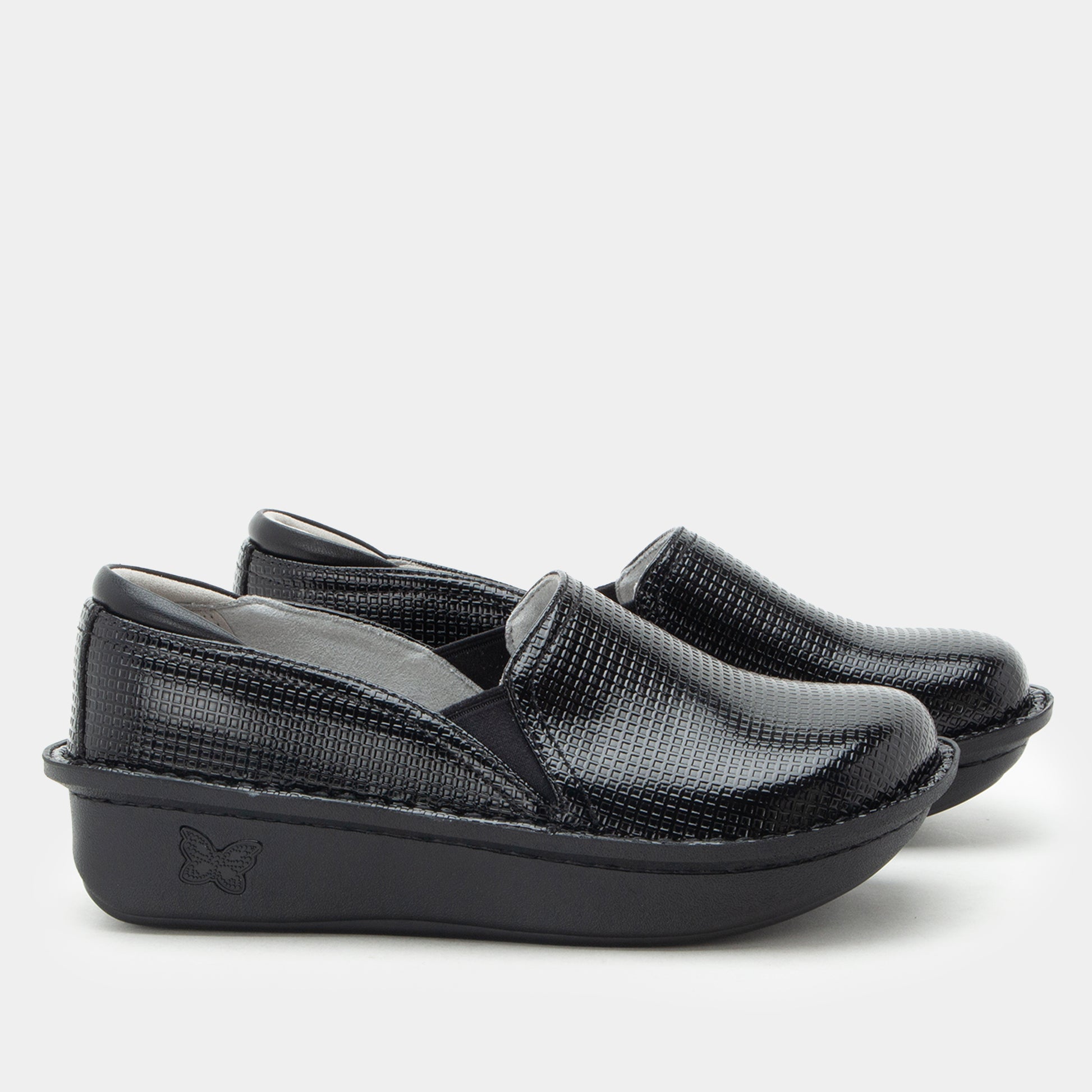 A pair of women's slip-on wedge shoes in black textured faux-croc leather, featuring a thick black platform sole with a debossed butterfly logo, shown against a light gray background.