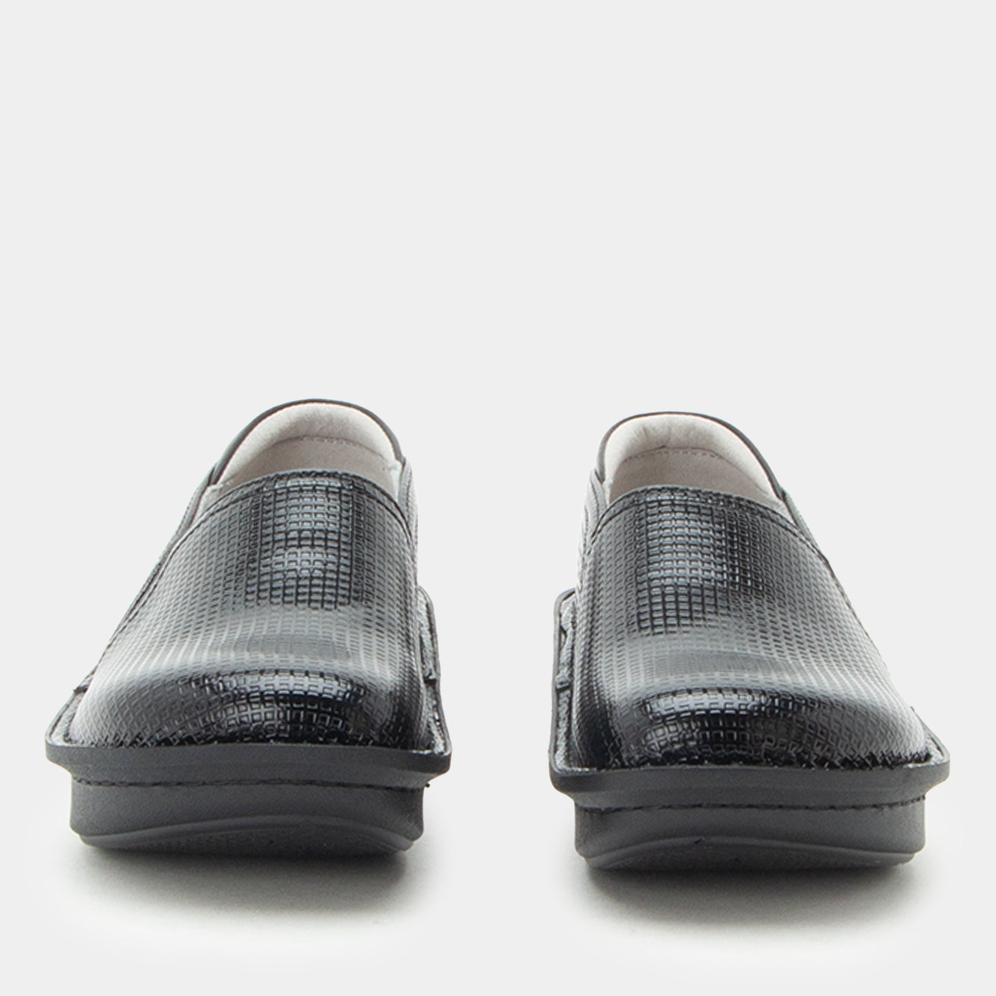 A pair of black textured slip-on shoes with a crocodile or python-style embossed pattern, shown from the front against a light gray background.