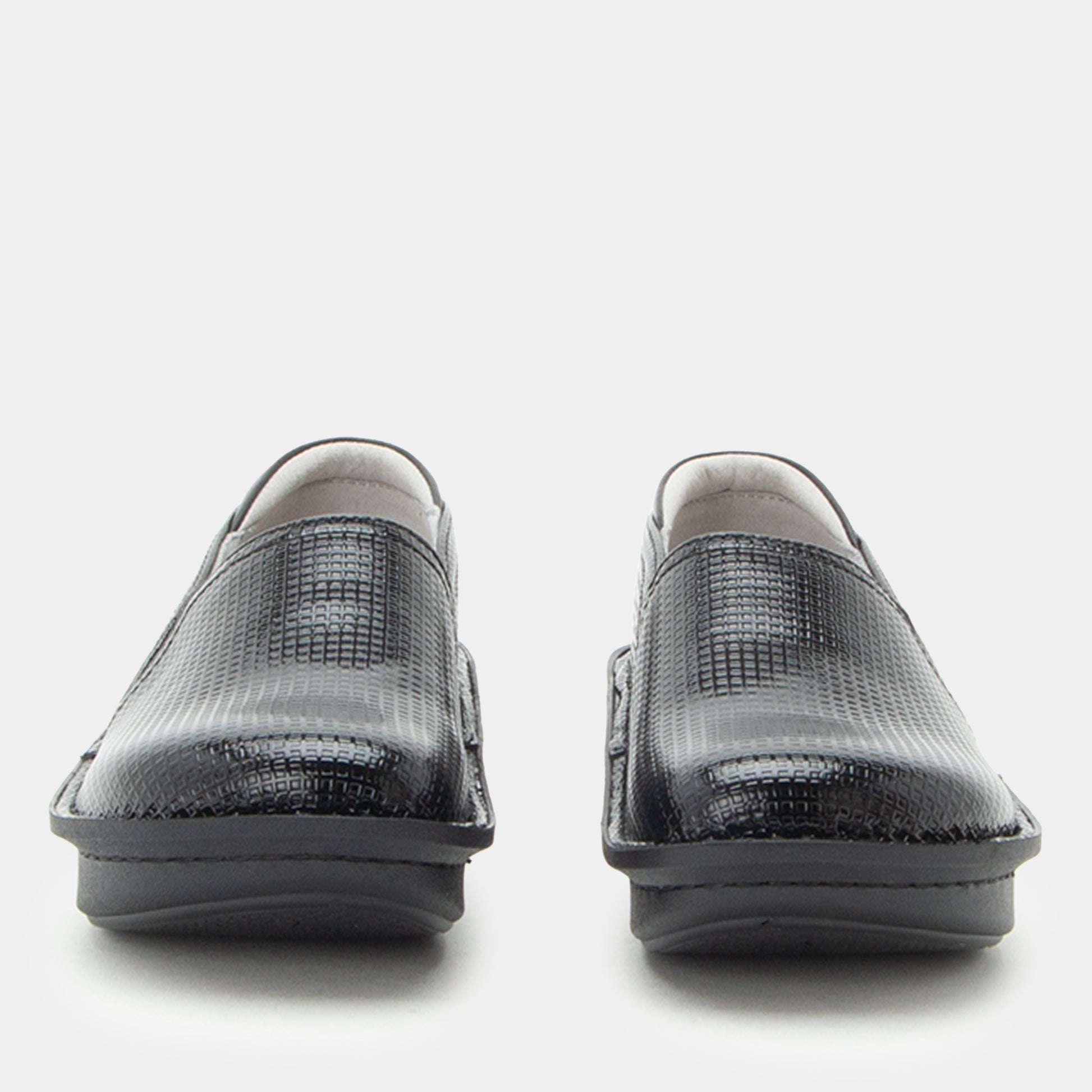 A pair of black textured slip-on shoes with a crocodile or python-style embossed pattern, shown from the front against a light gray background.