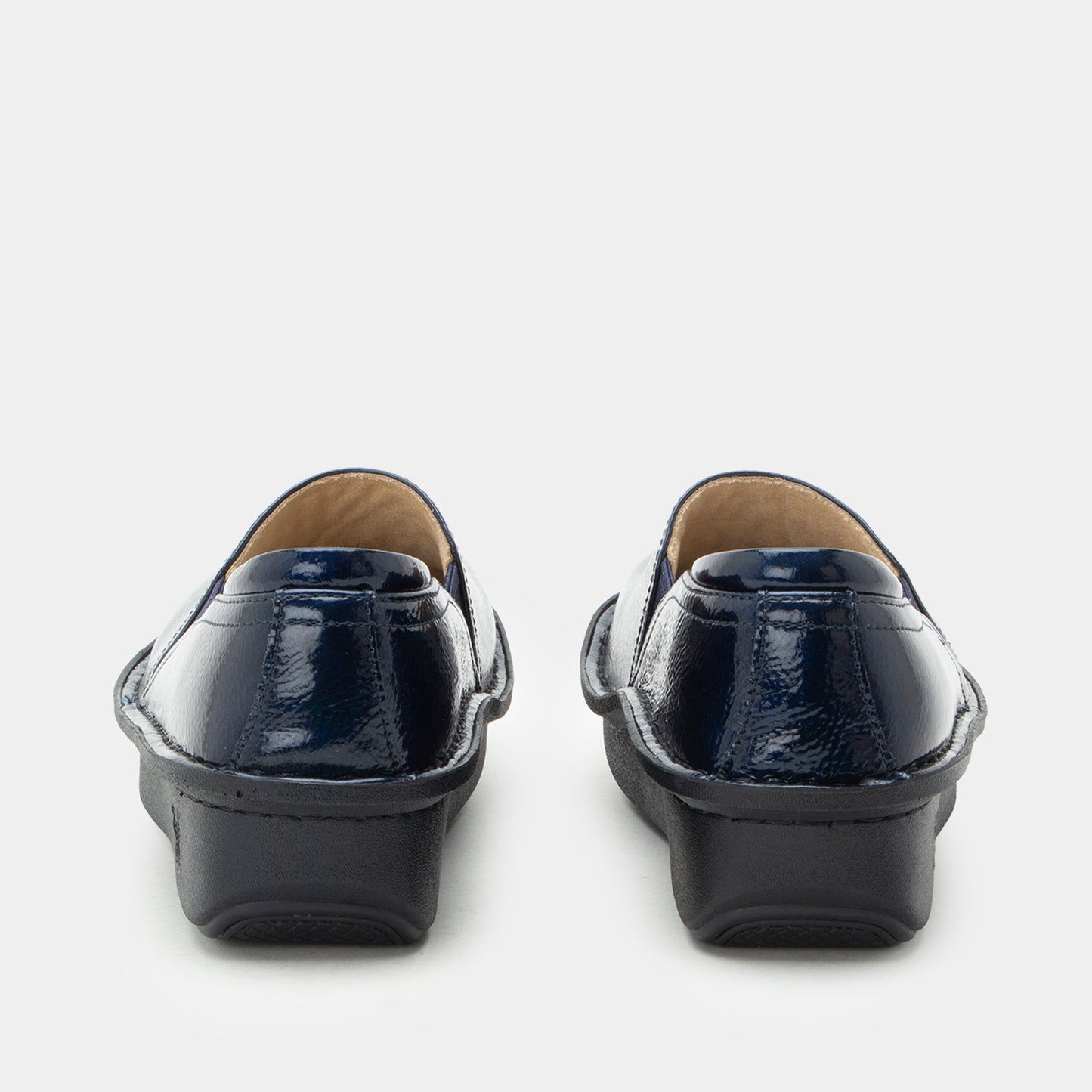 A pair of women's slip-on loafers shown from the back, featuring a glossy navy blue patent leather upper and a chunky black platform sole, set against a plain light gray background.