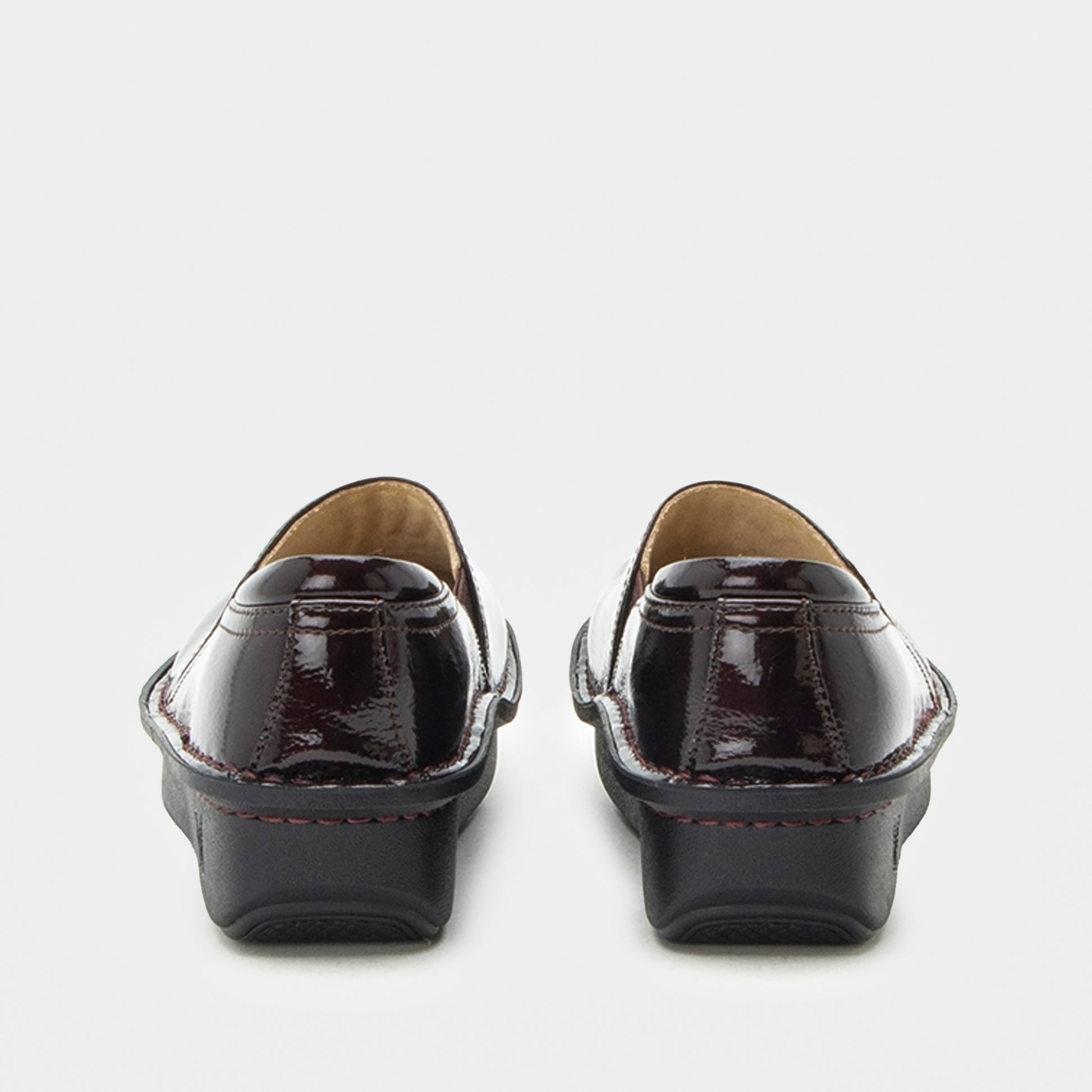 A pair of women's patent leather loafers shown from the back, featuring a glossy deep burgundy finish with black platform soles and contrast stitching.