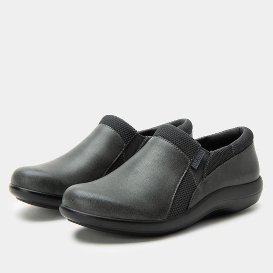 Pair of gray slip-on shoes with black straps on a light gray background