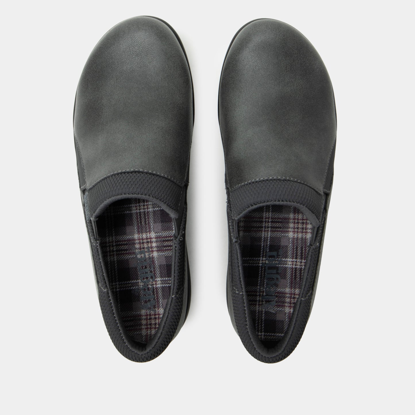 Pair of gray slip-on shoes with plaid lining on a white background