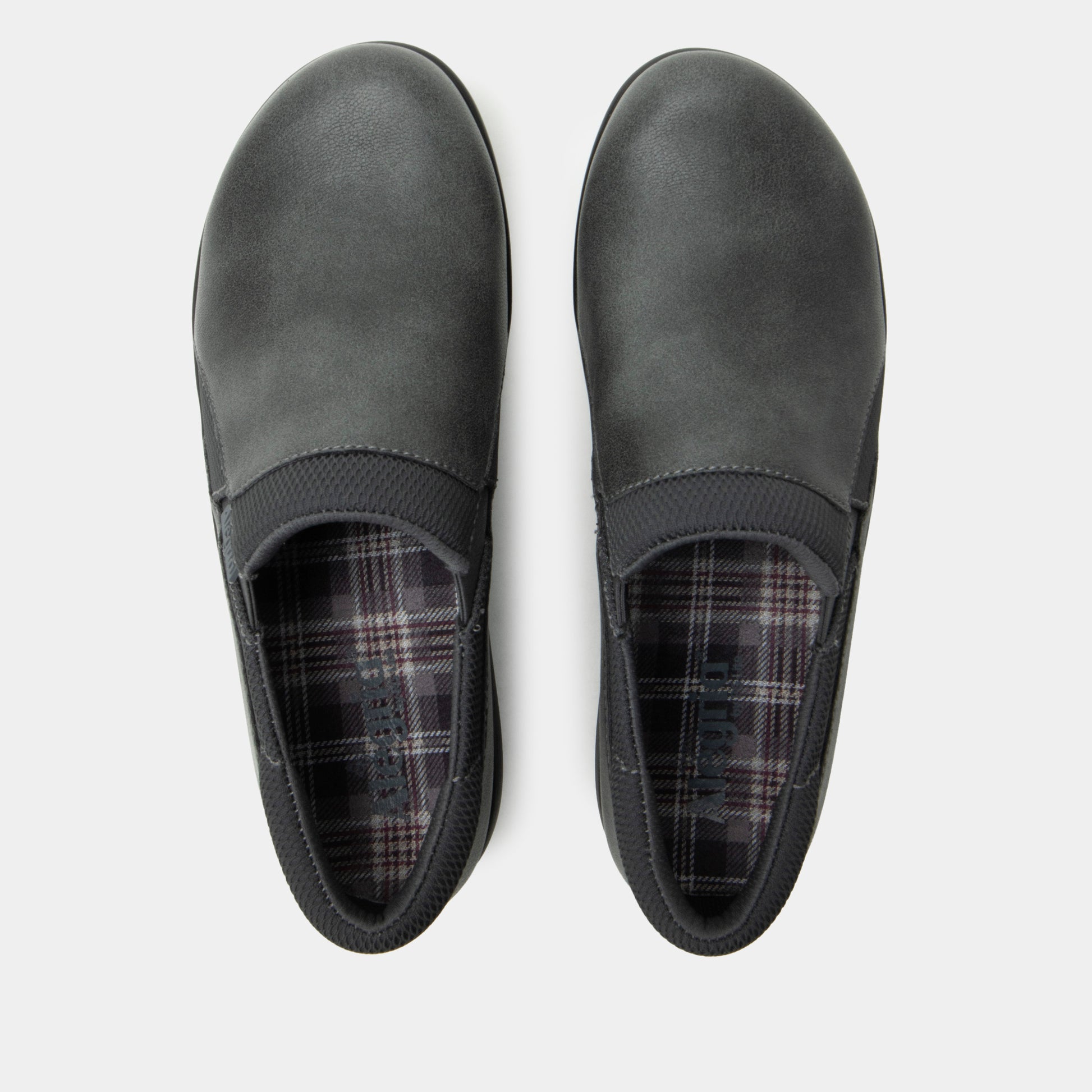 Pair of gray slip-on shoes with plaid lining on a white background