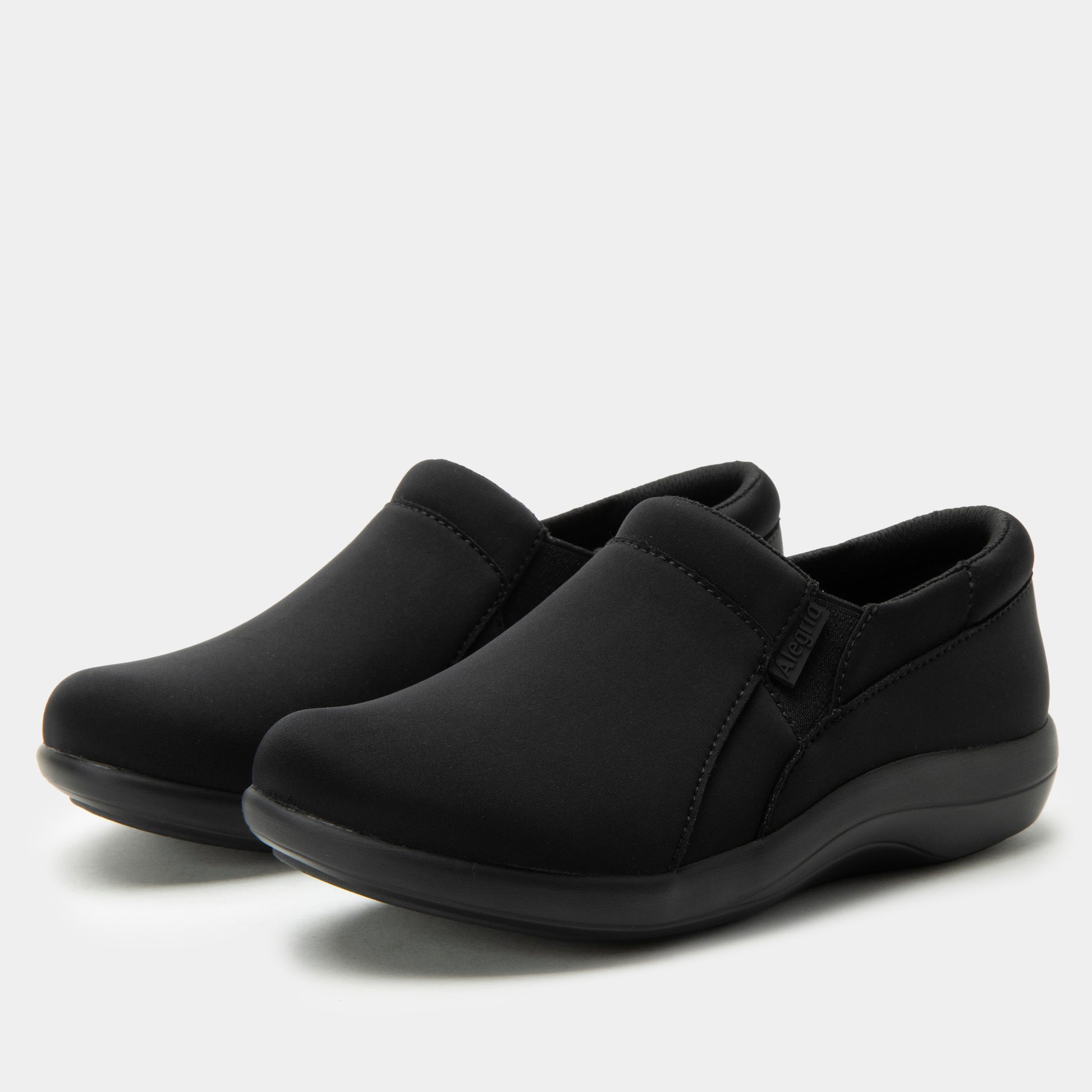 Pair of black slip-on shoes on a light gray background