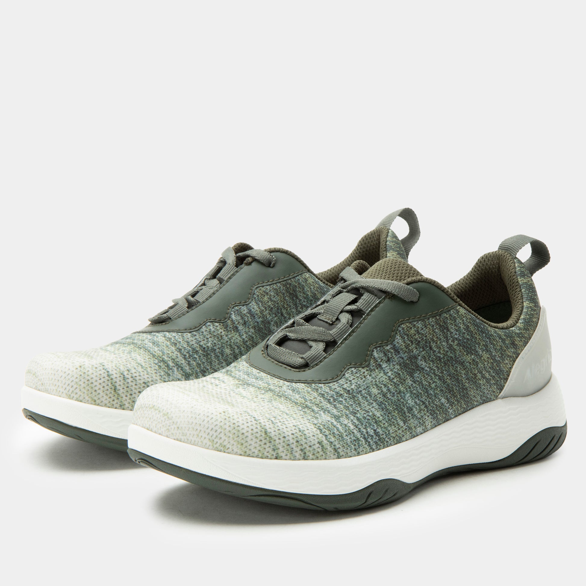 Pair of green and white sneakers on a light gray background