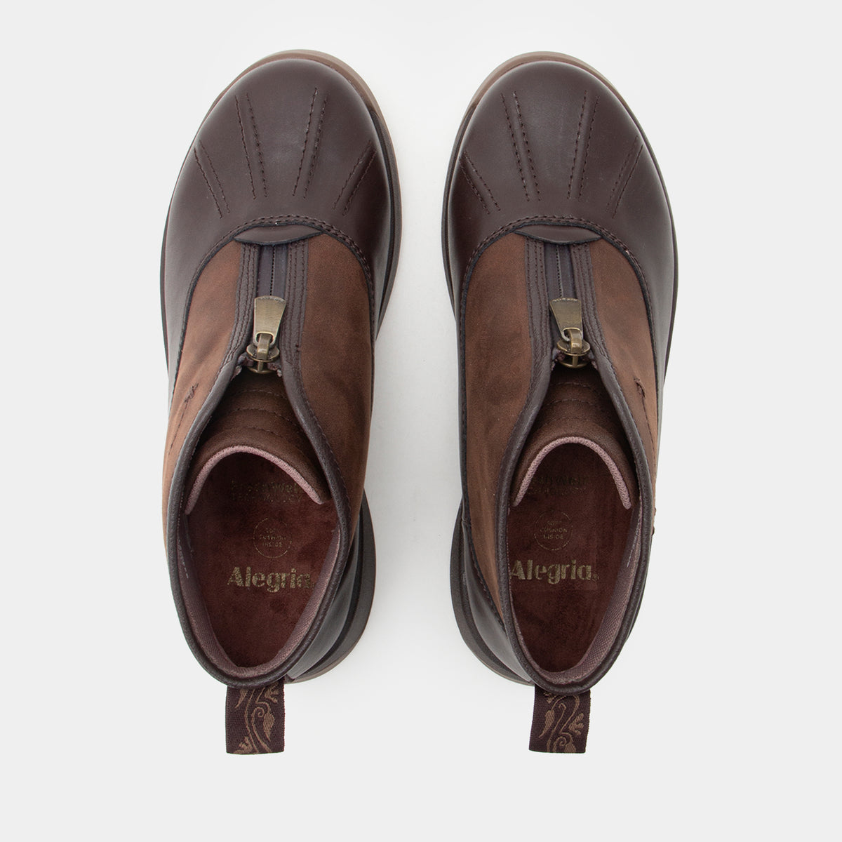 A pair of dark brown leather ankle boots with a side zipper, shown from a top-down view on a light gray background. The brand name 'Alegria' is visible on the inner sole.
