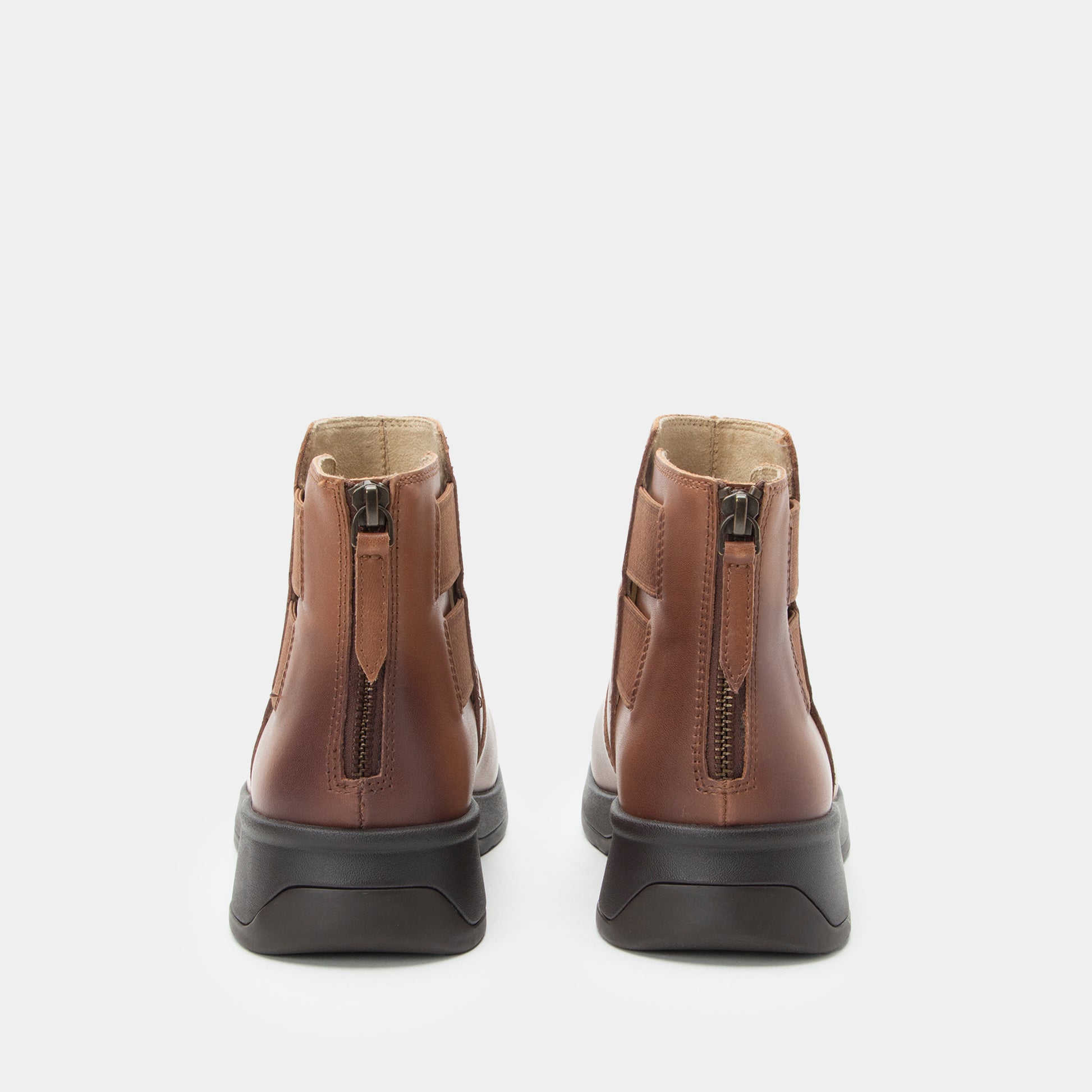 Pair of brown leather boots with zippers on a white background
