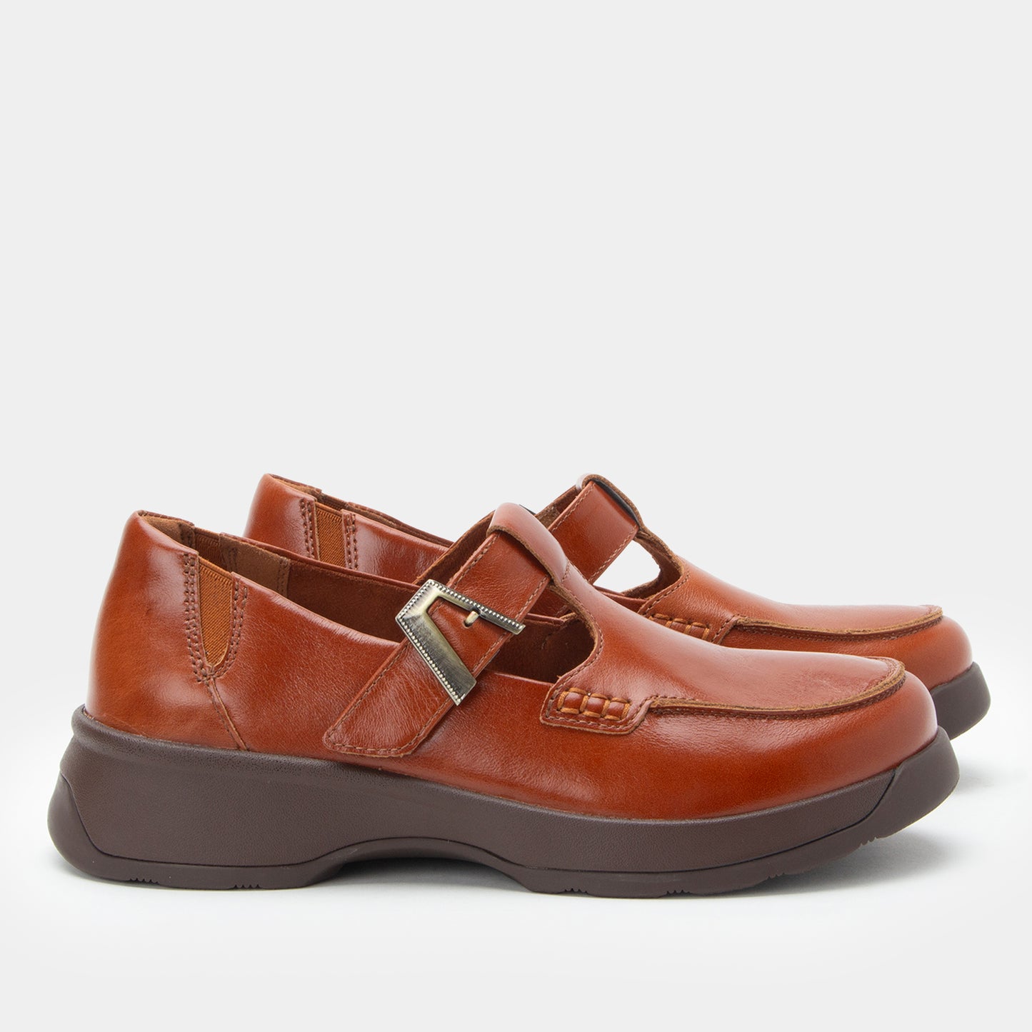 Pair of brown leather shoes with a buckle on a white background