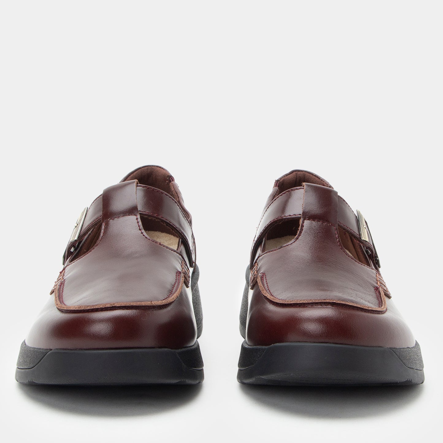 Pair of brown shoes with black soles on a white background