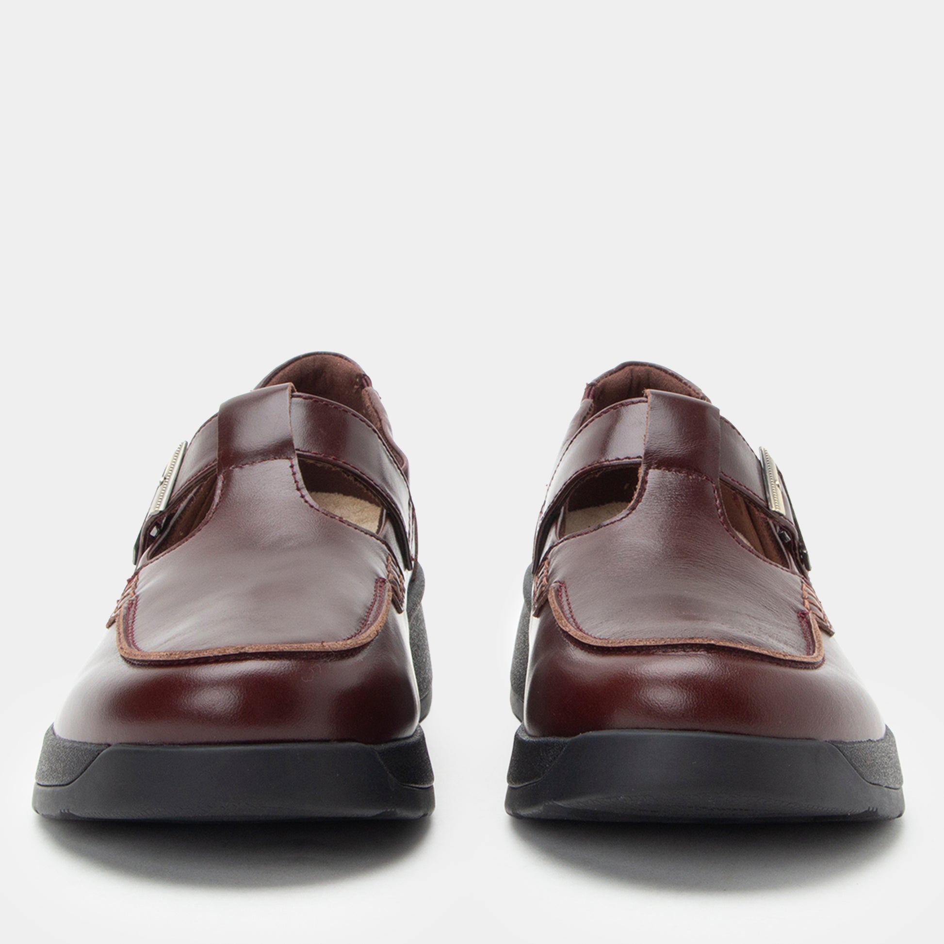 Pair of brown shoes with black soles on a white background
