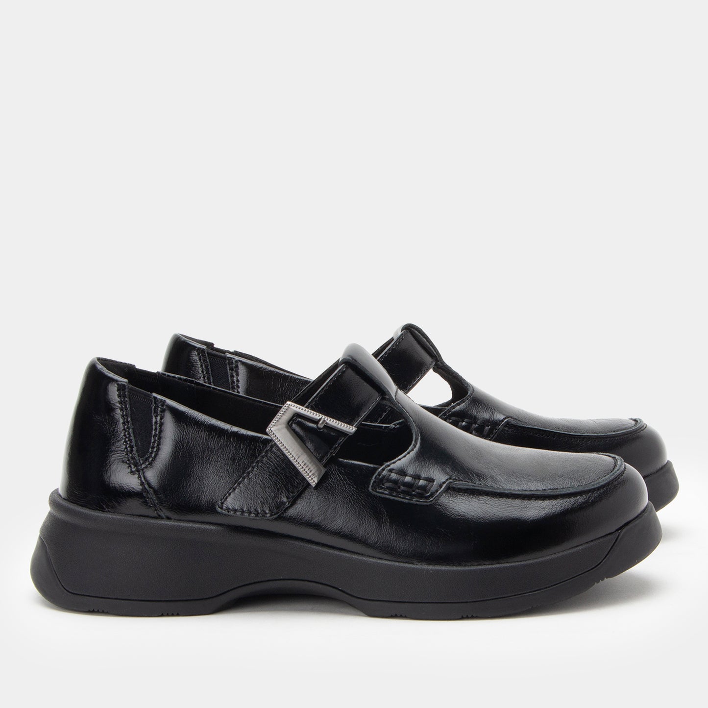 Pair of black leather shoes with a buckle on a white background