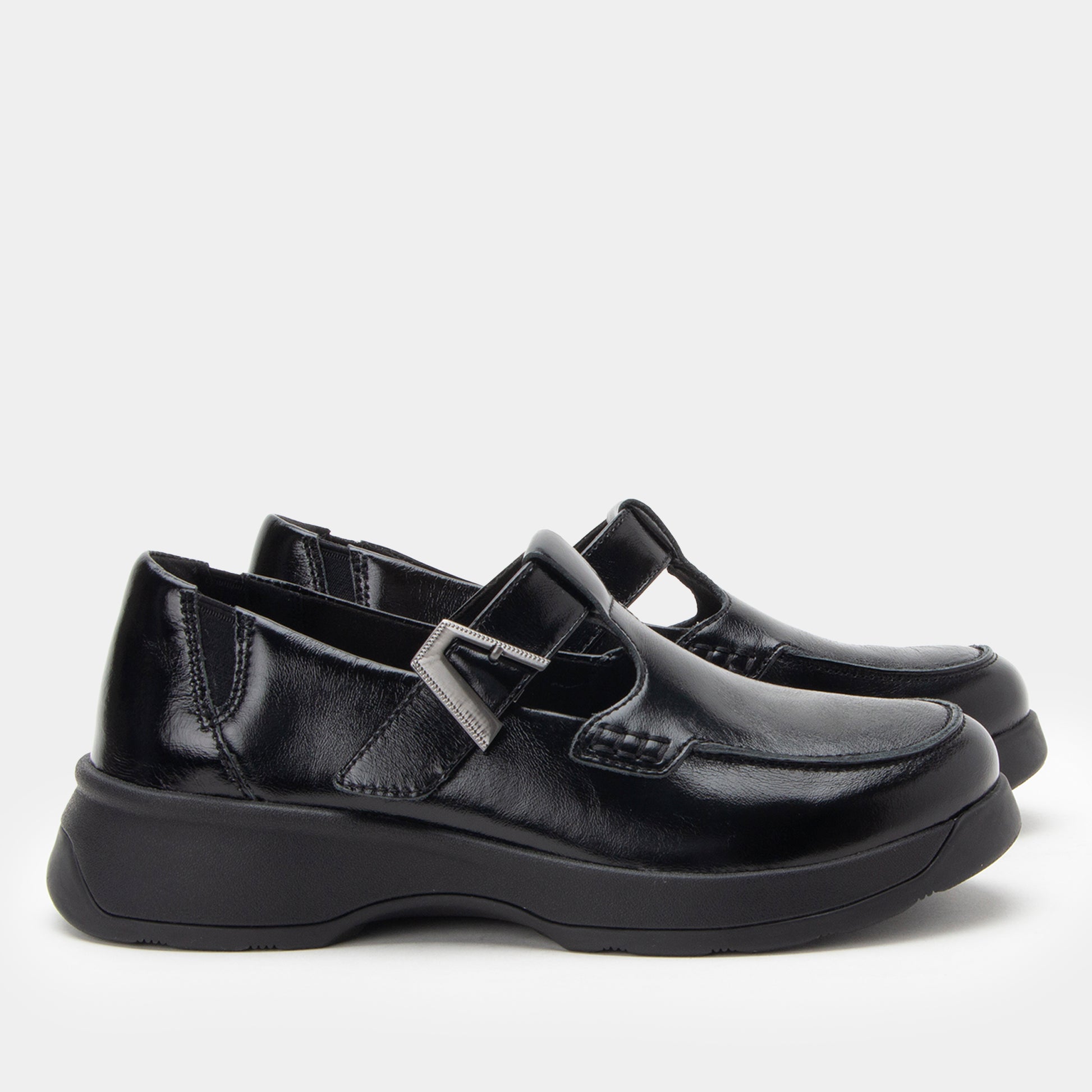 Pair of black leather shoes with a buckle on a white background