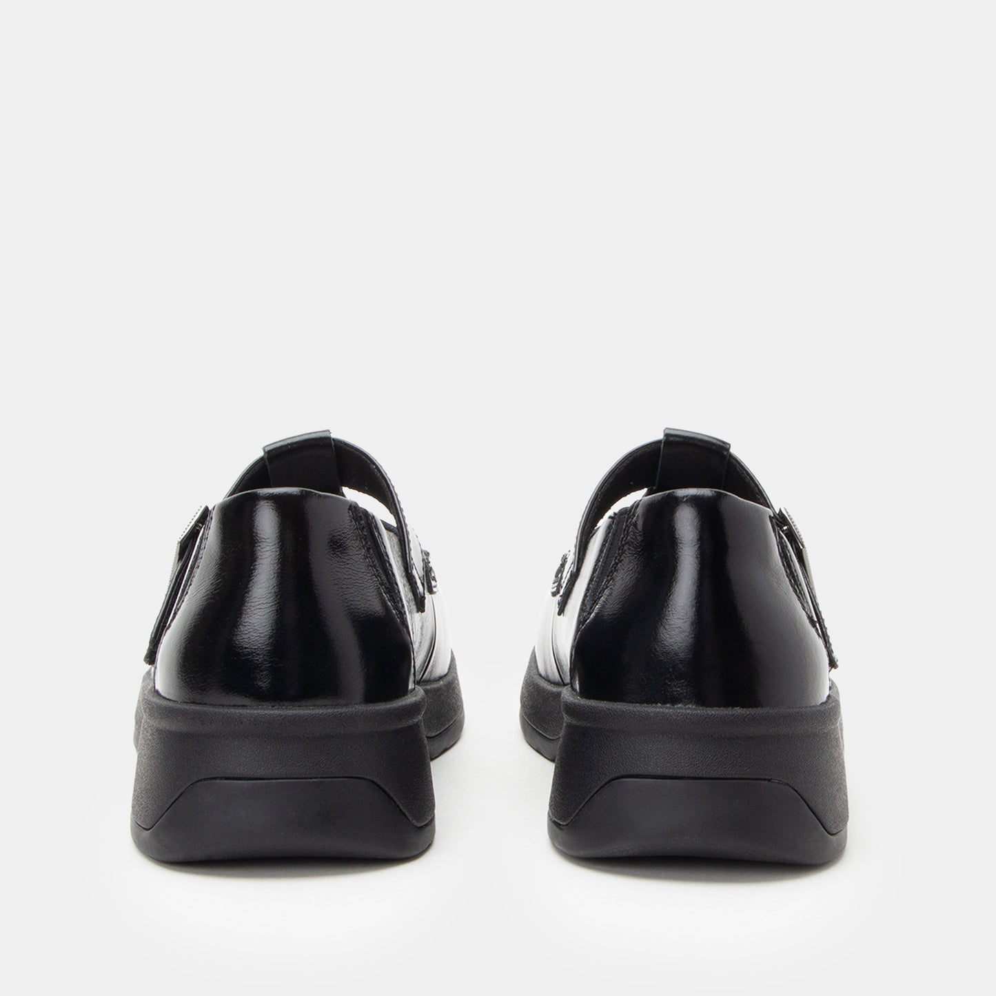 Black slip-on shoes with a thick sole on a white background