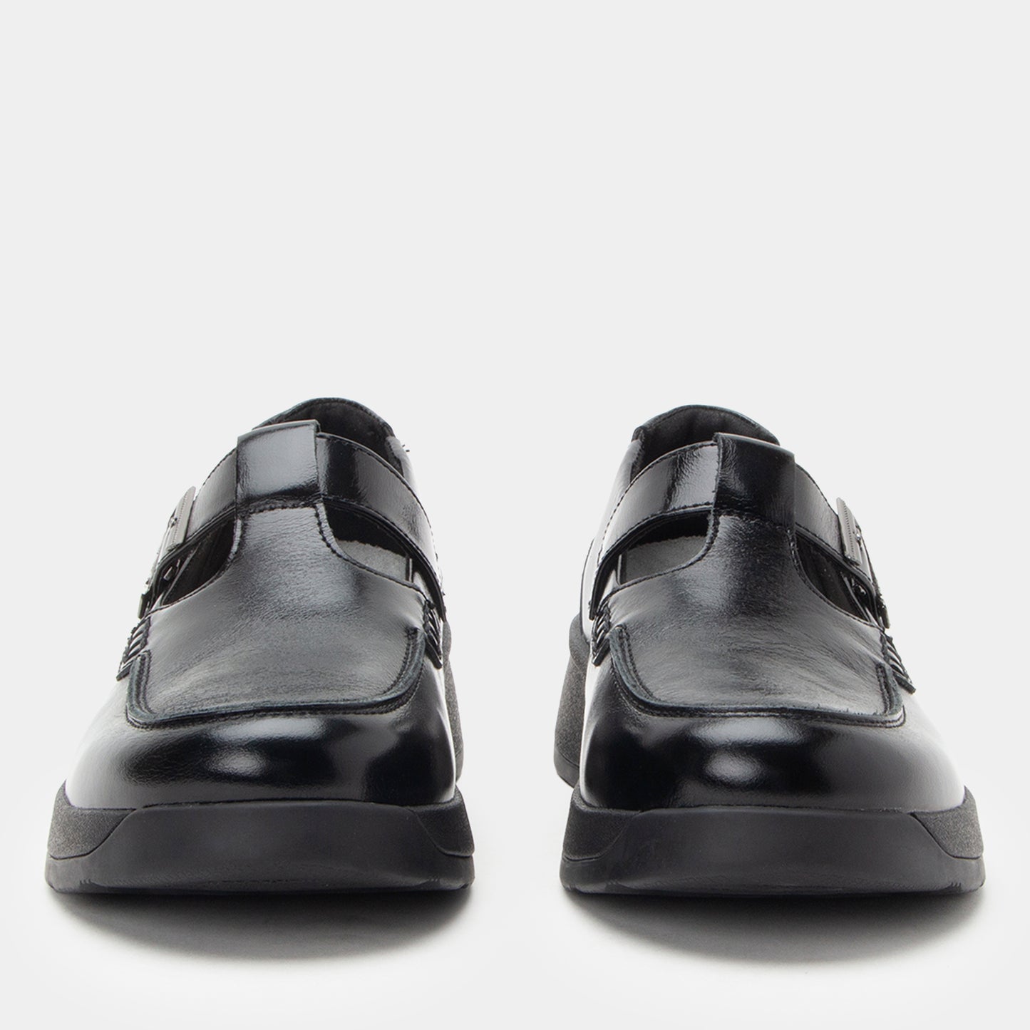 Black leather shoes with velcro straps on a light gray background