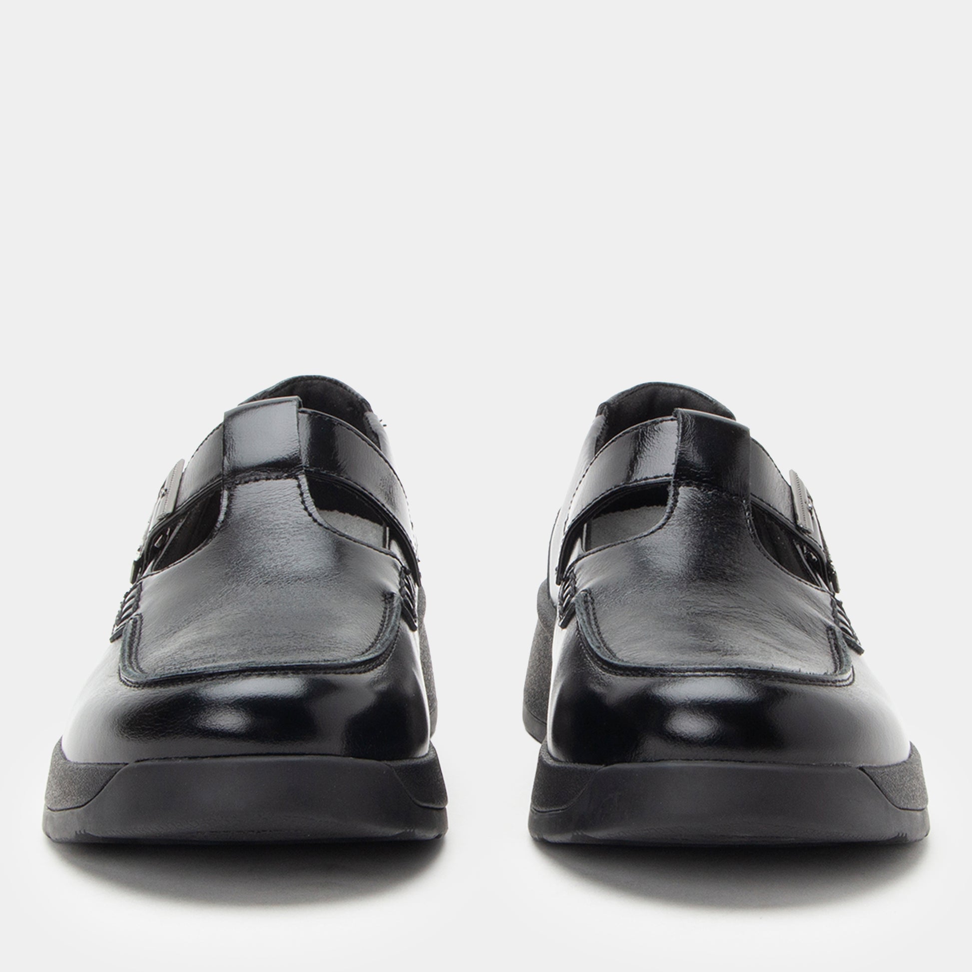 Black leather shoes with velcro straps on a light gray background