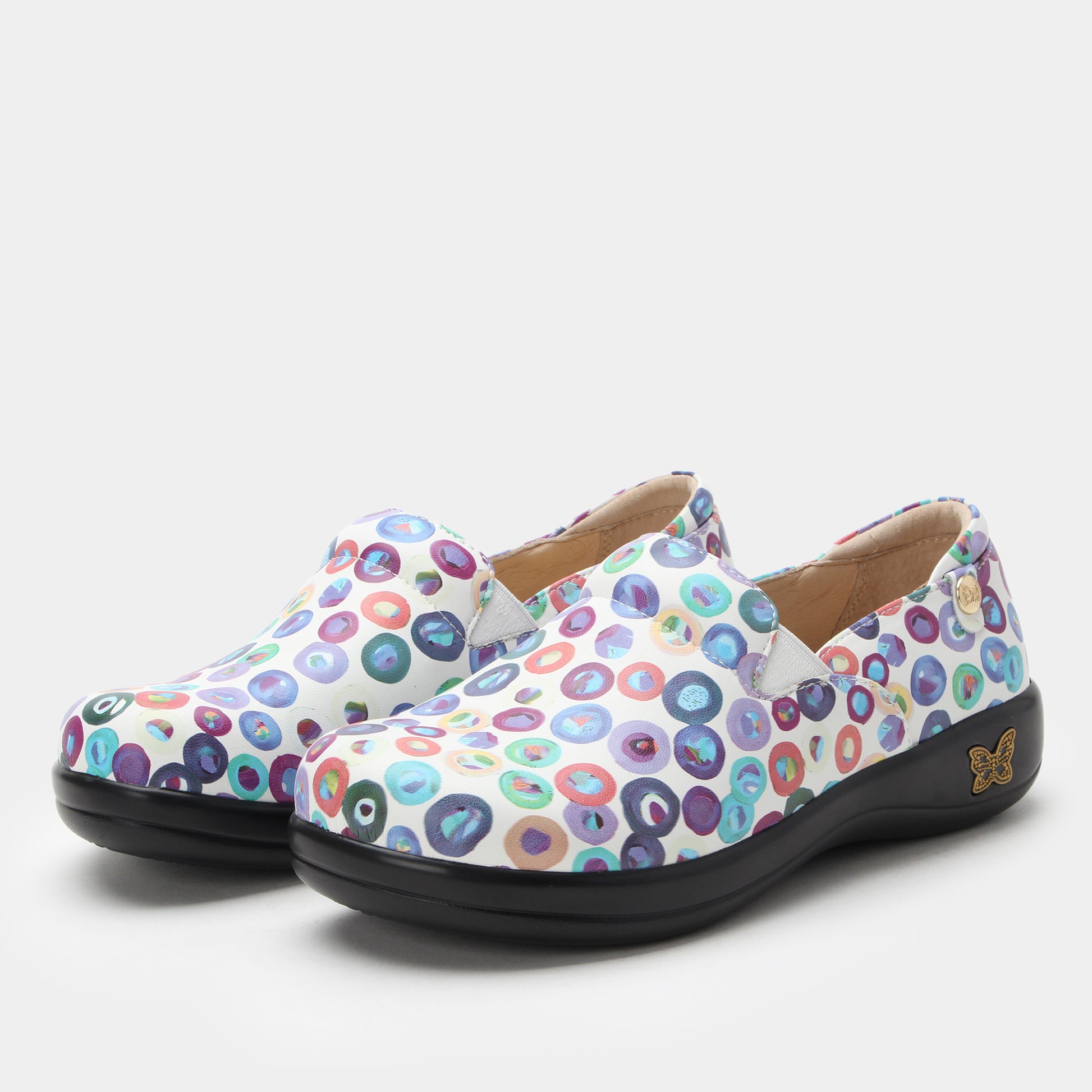 Pair of colorful polka dot shoes on a light gray background