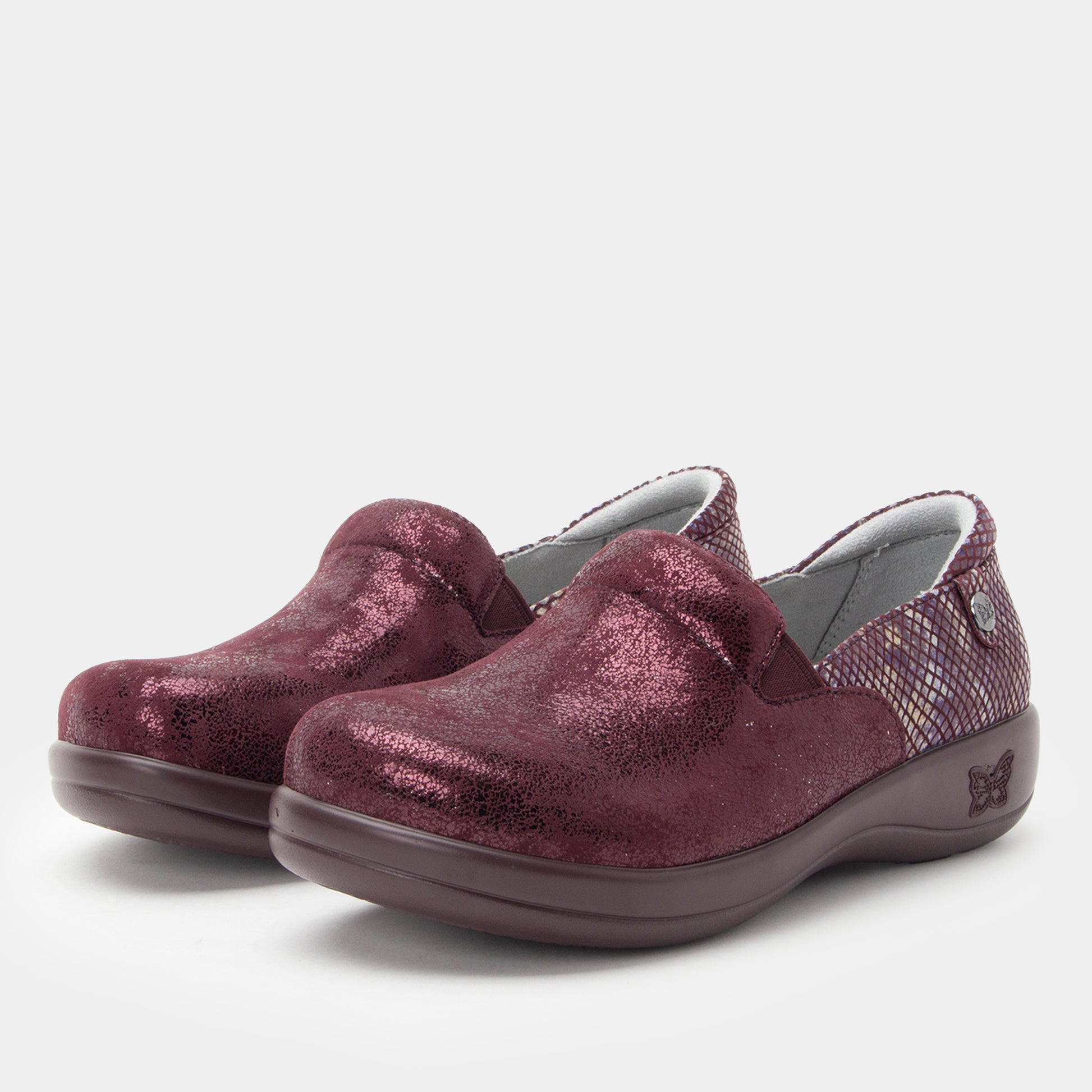 Pair of maroon slip-on shoes on a light gray background
