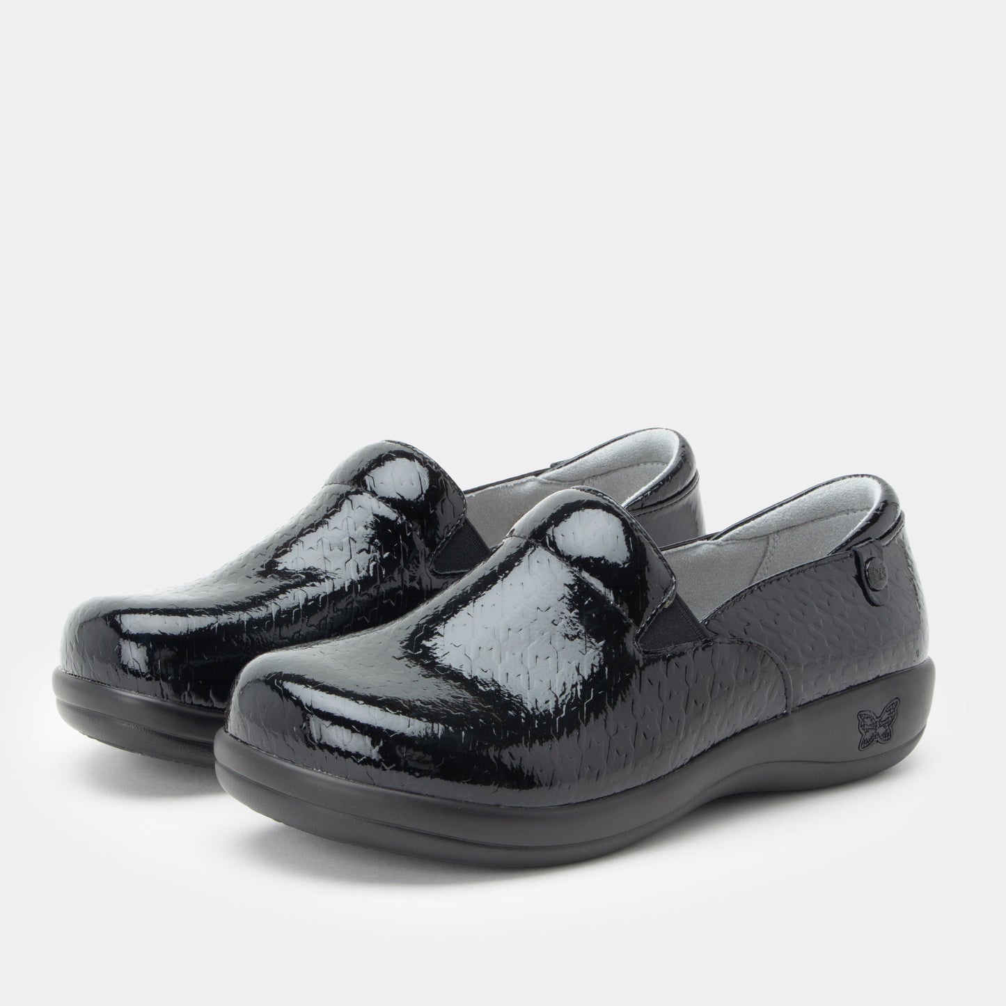 Black patent leather shoes on a light gray background