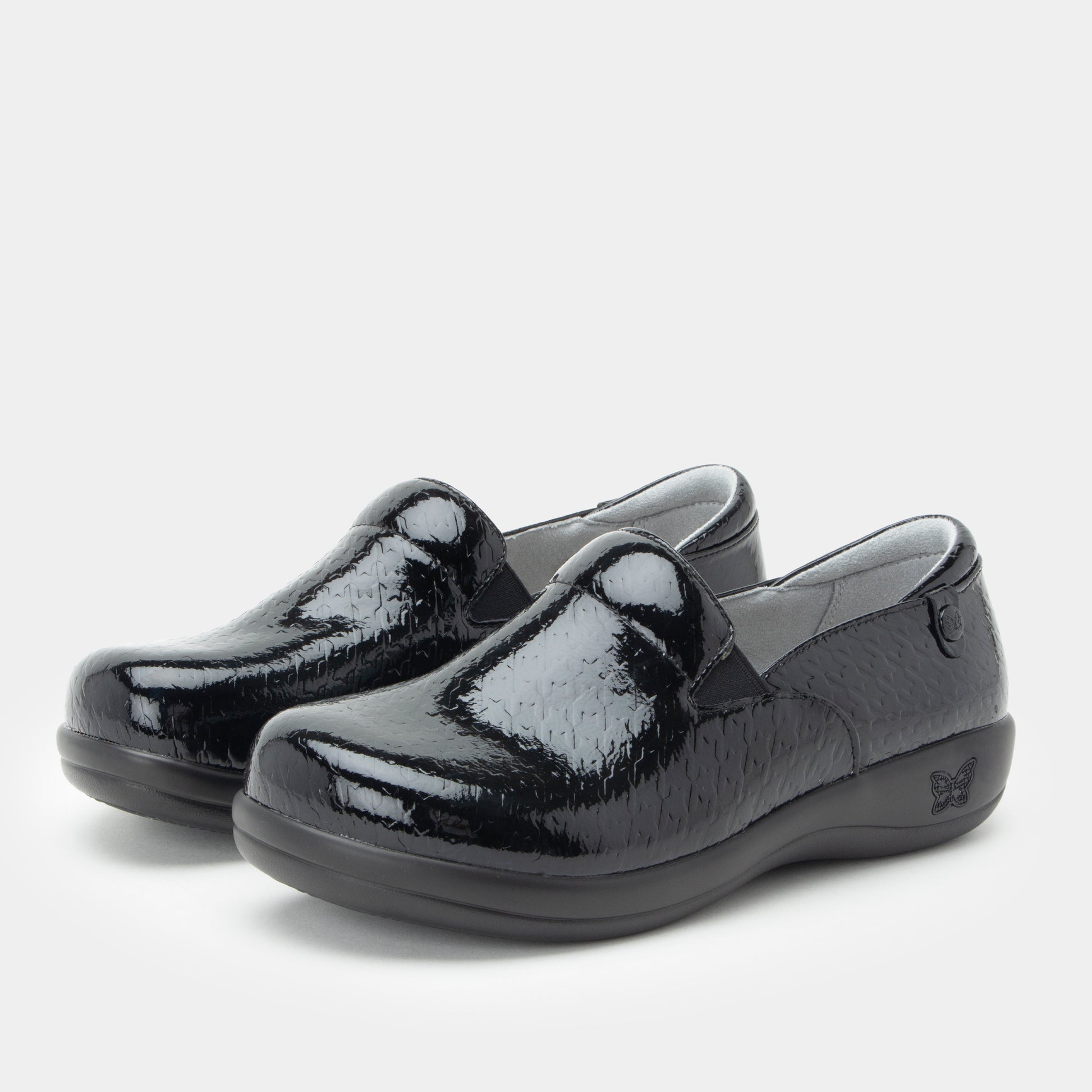 Black patent leather shoes on a light gray background