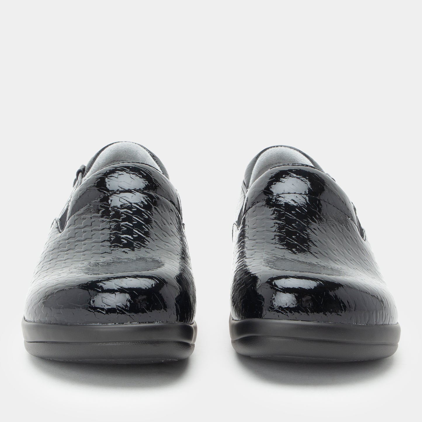 Black patent leather shoes on a white background