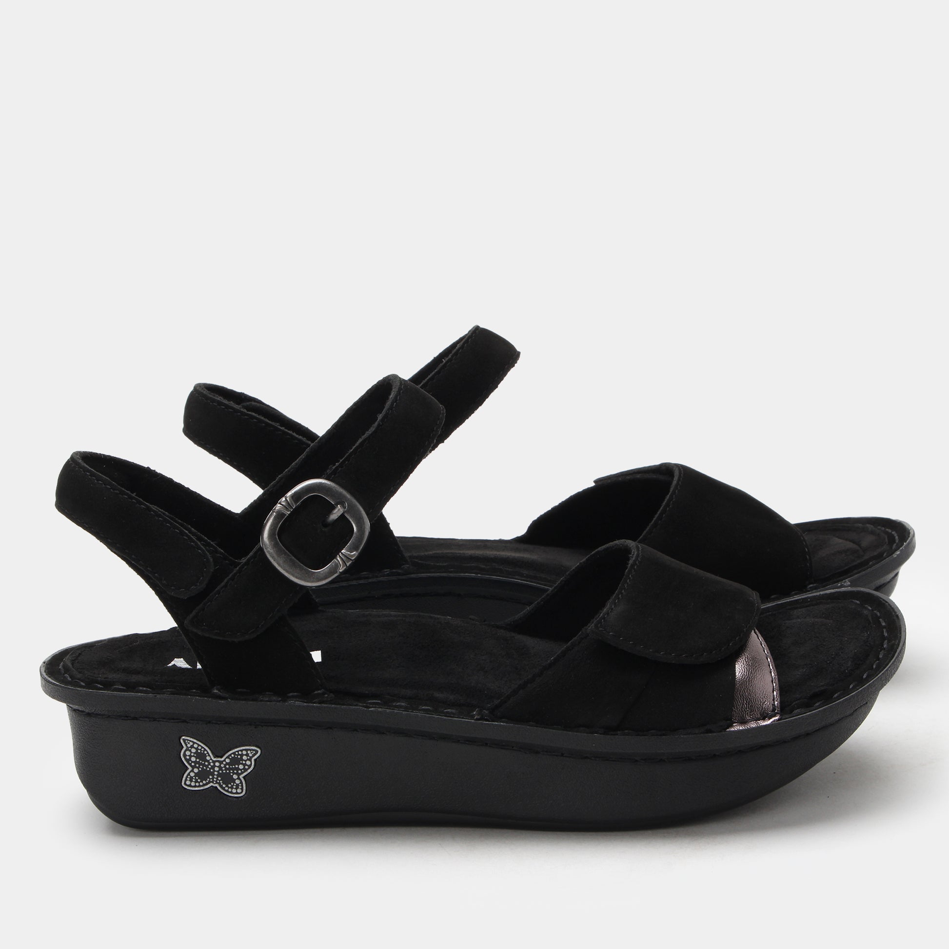 Black sandals with a decorative buckle on a white background