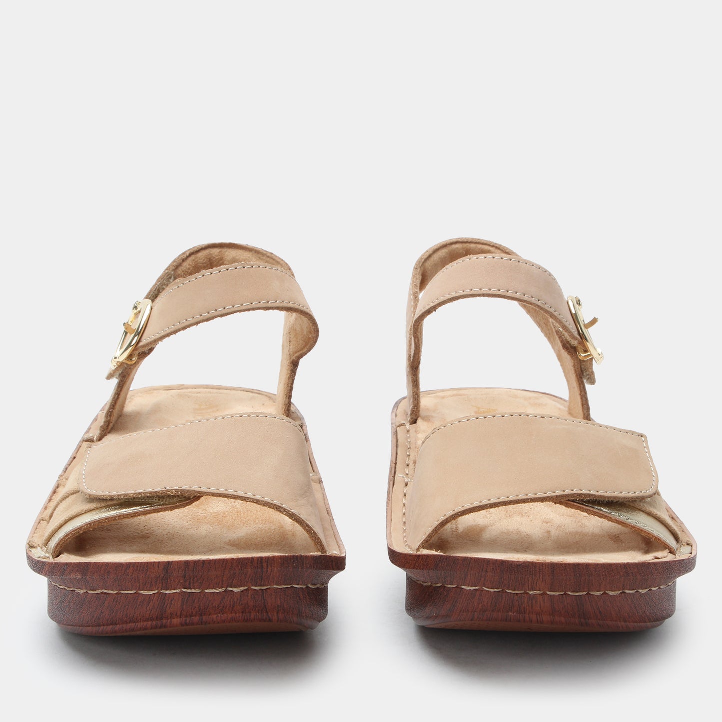 Pair of beige sandals with wooden soles on a white background